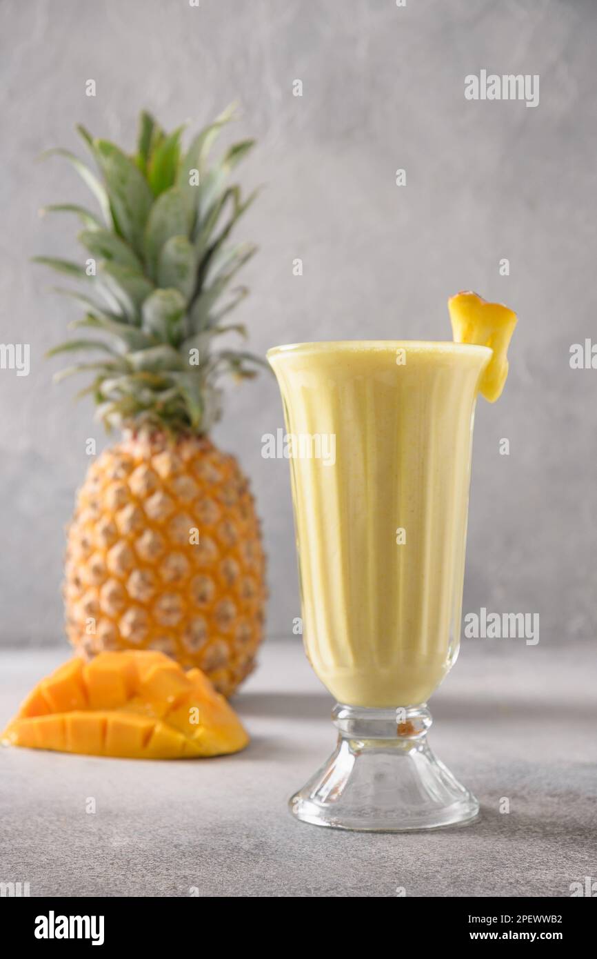 Asiática piña y mango lassi, smoothie sobre fondo gris. Bebida de