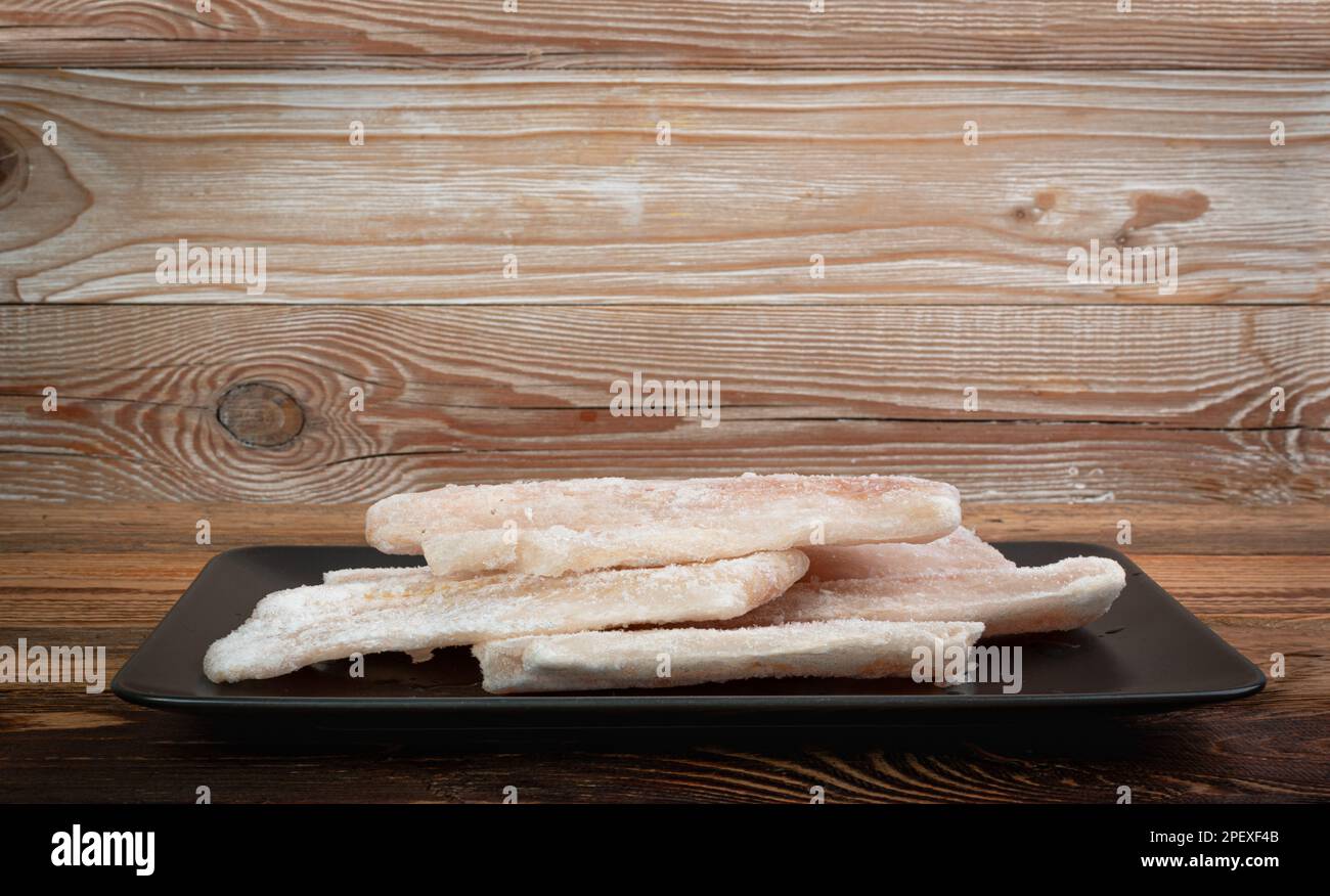 Pescado congelado en negro aislado, filete de bacalao blanco, filete de merluza helada, carne de Pollock congelada sobre fondo blanco Foto de stock