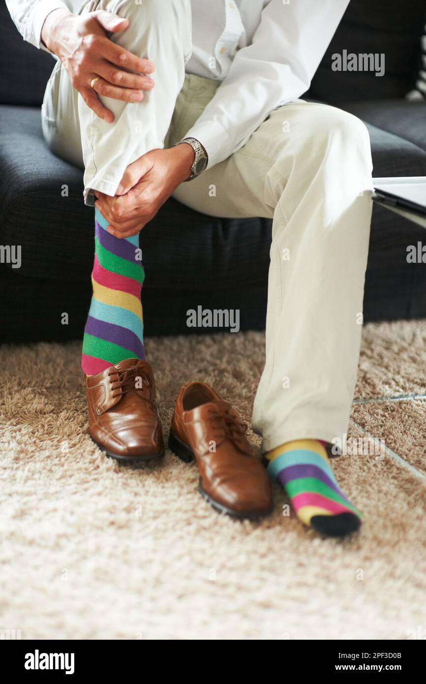 Añadiendo un poco de diversión al outfit. un hombre poniéndose calcetines y  mocasines de colores Fotografía de stock - Alamy