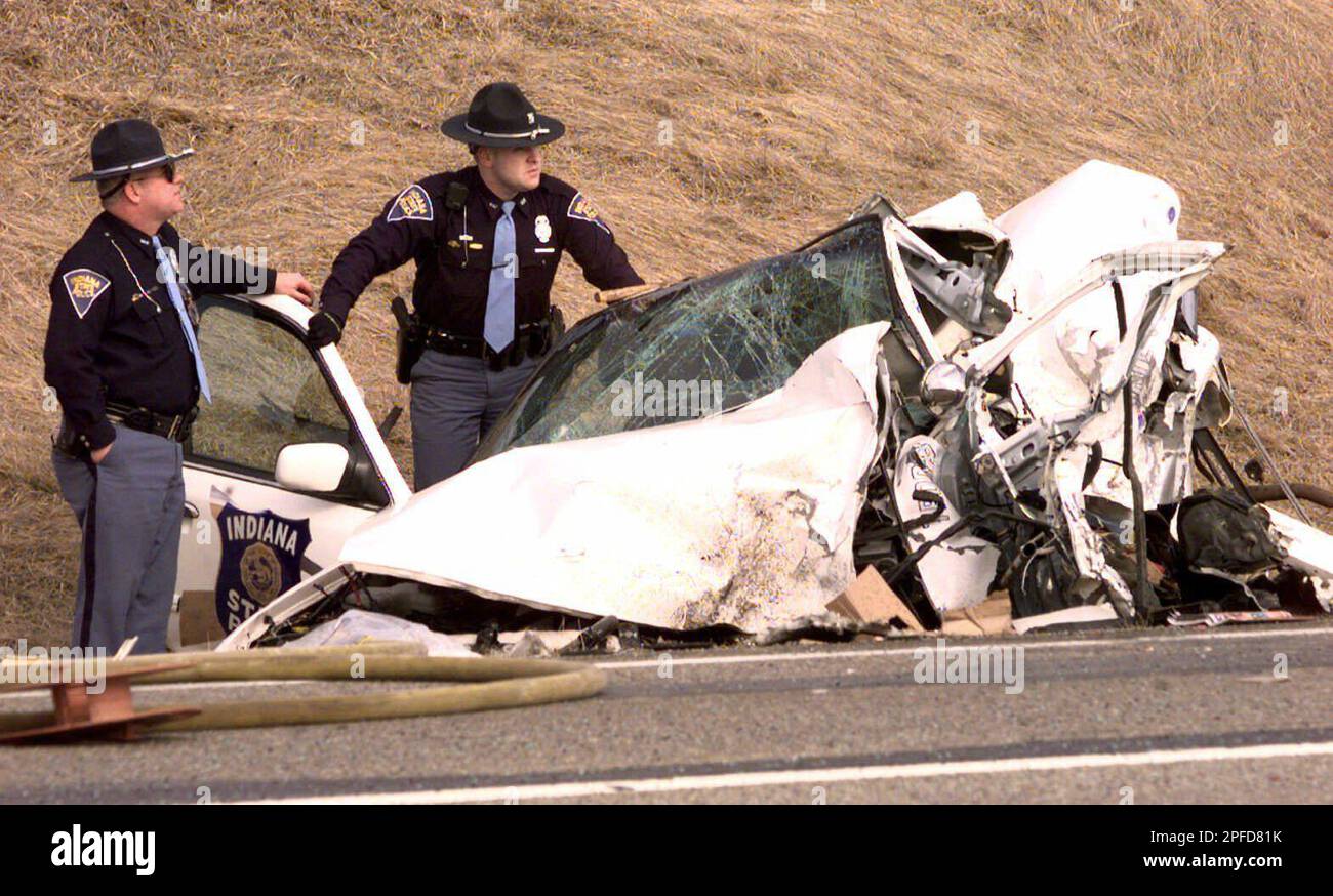 Indiana State Troopers look over the wreckage of a police cruiser following a fatal accident on
