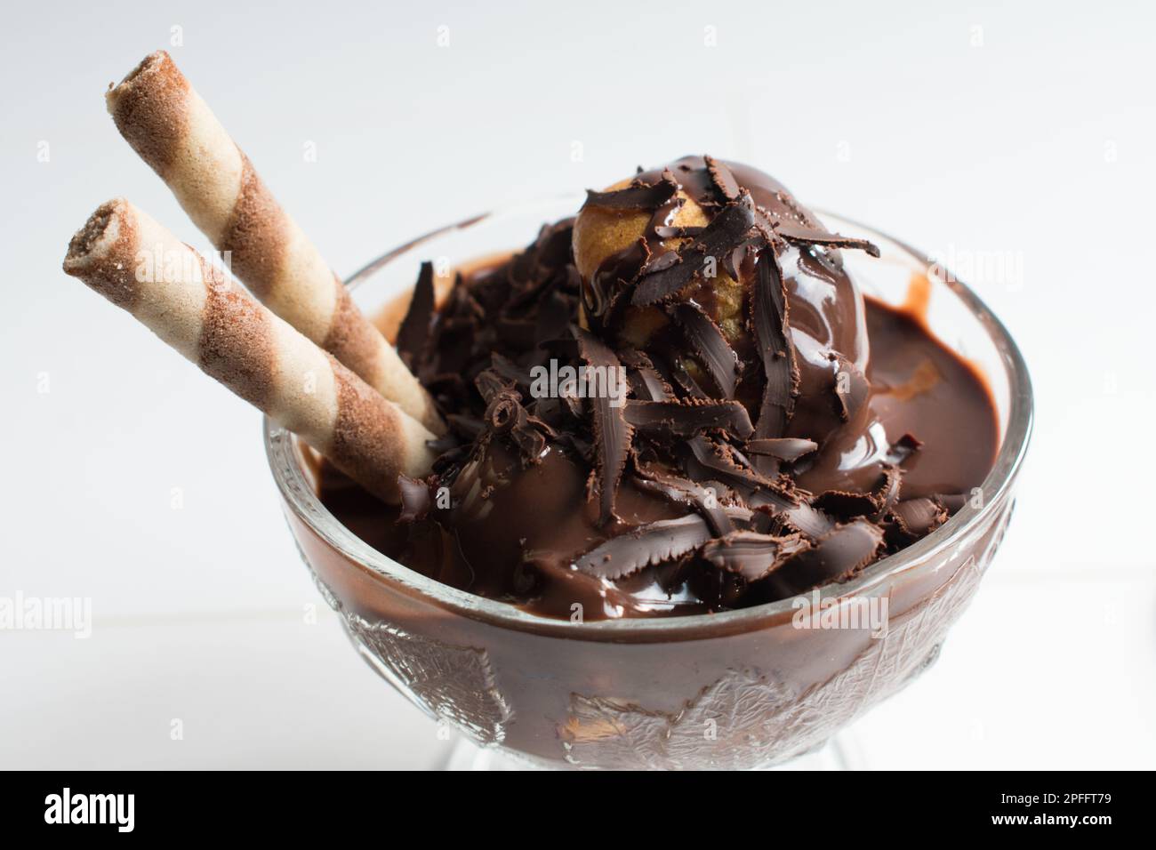 Deliciosos profiteroles con chocolate, profiteroles sobre fondo blanco aislado, primer plano. Foto de stock