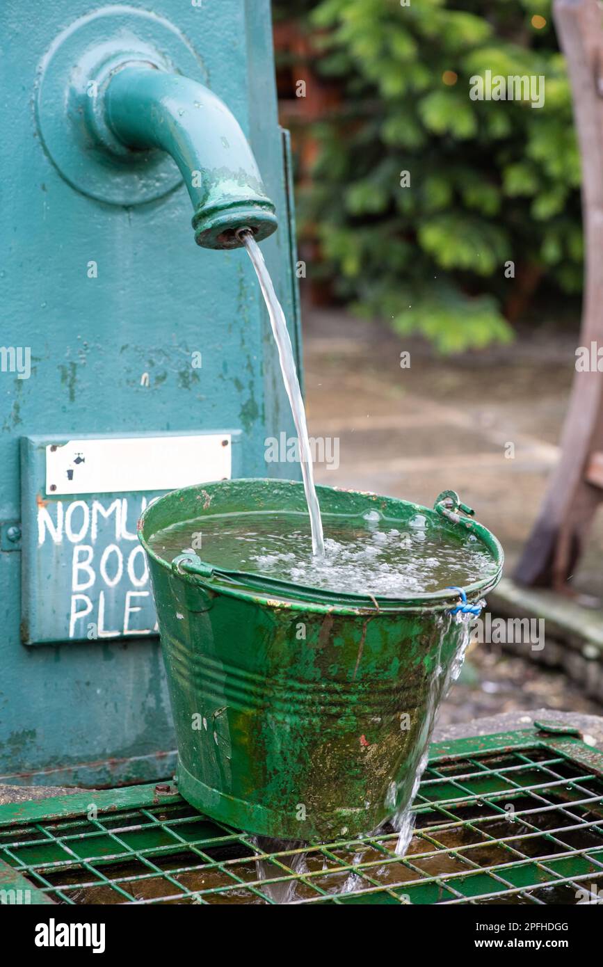Old Green Bucket Metal Pail Relleno de agua Caño de agua Agua Fresca UKAgua limpia Foto de stock