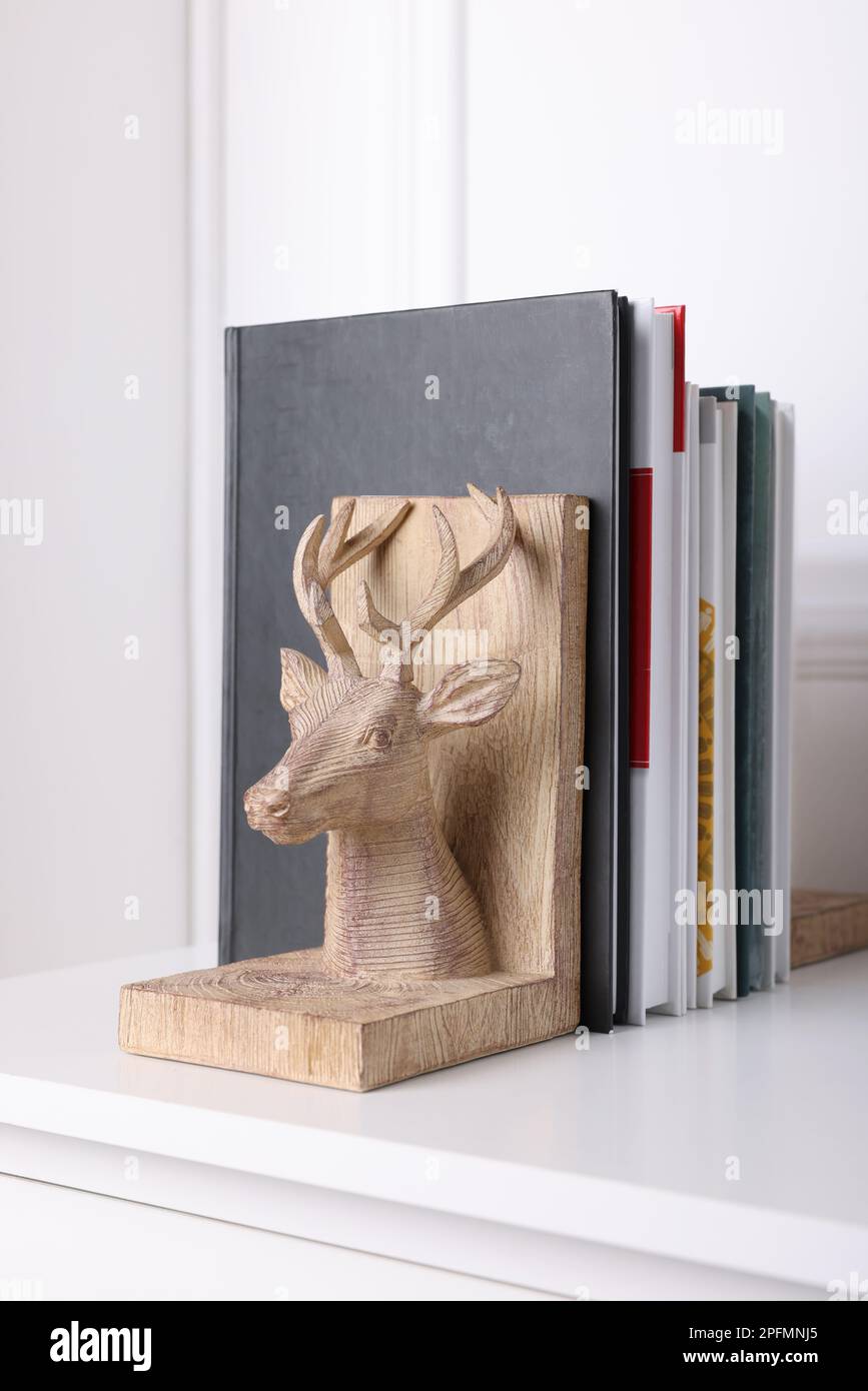 Libro de libros en forma de ciervo de madera con libros en la mesa en el interior Foto de stock