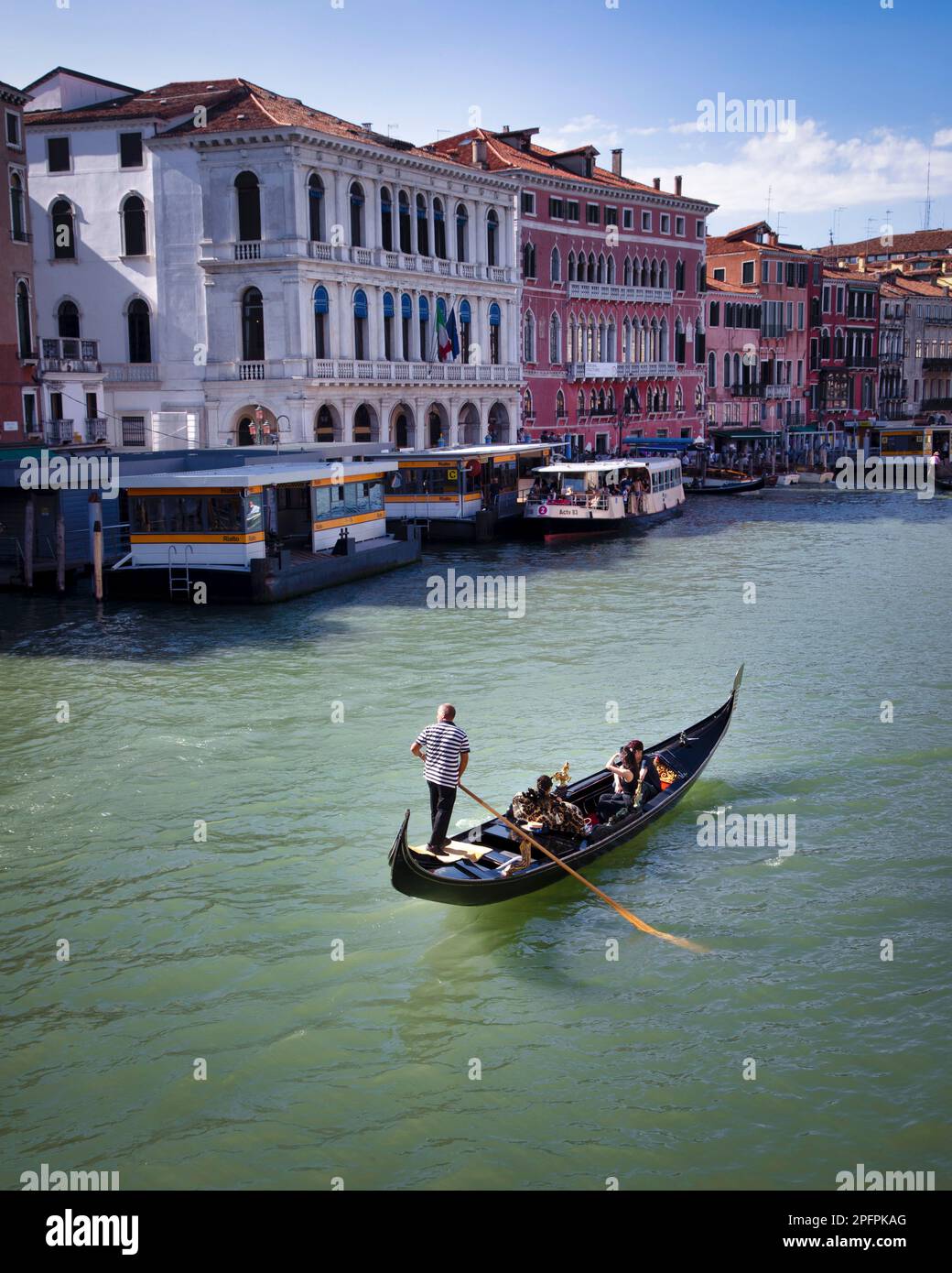 Una pareja disfruta de la vista del Gran Canal de Venecia desde una góndola. Foto de stock