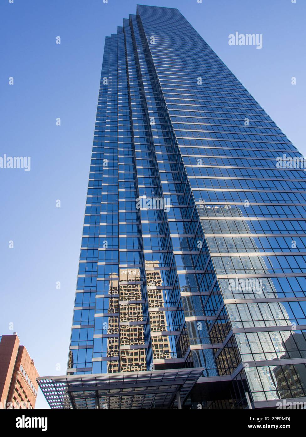 Sumérjase en la impresionante arquitectura del centro de Dallas con esta impresionante imagen de un rascacielos con una fachada de vidrio y reflejos. AGA Foto de stock