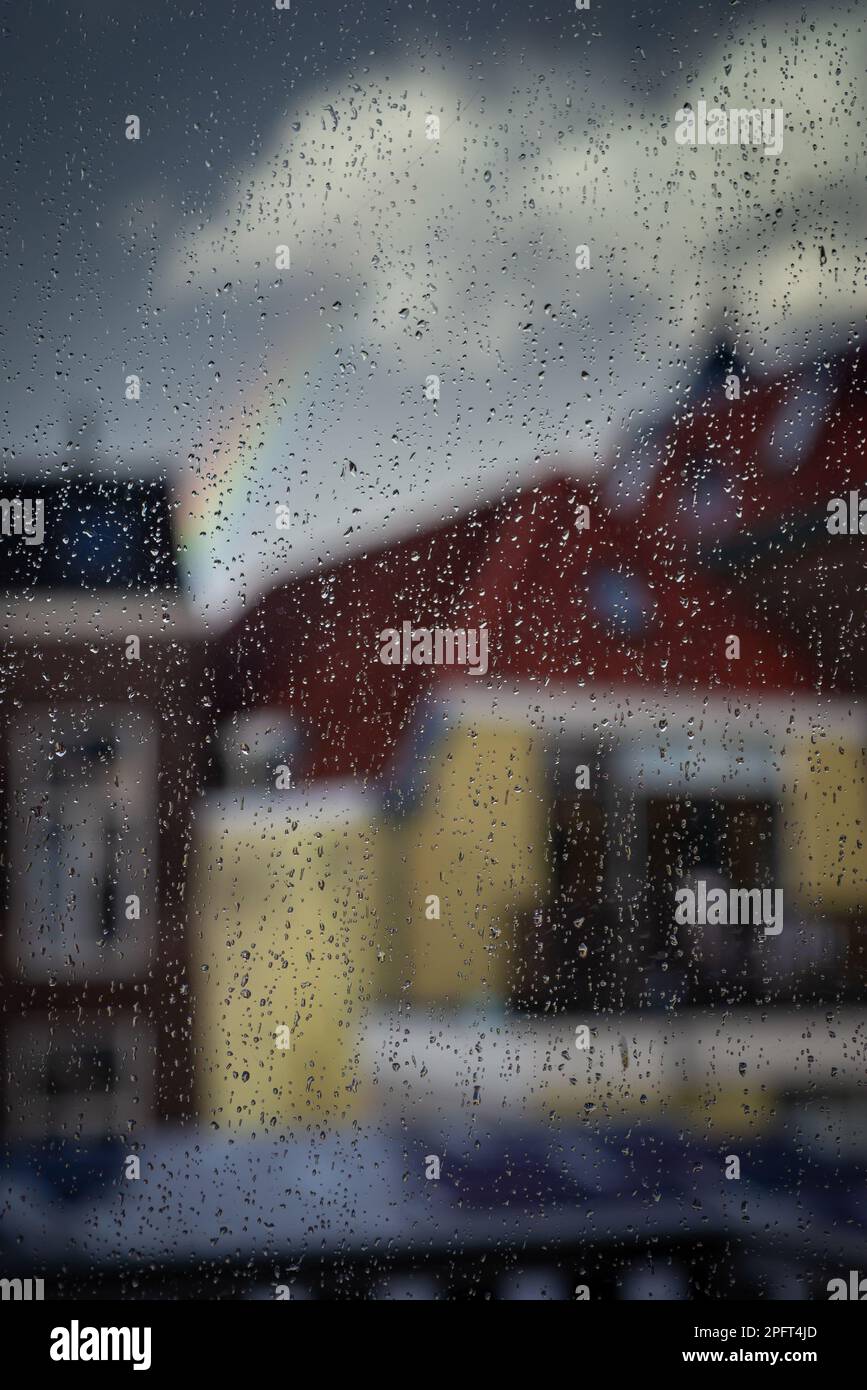 Gotas de lluvia en un cristal de ventana, lluvia de ventana borrosa ciudad, lluvia en vidrio. Foto de stock