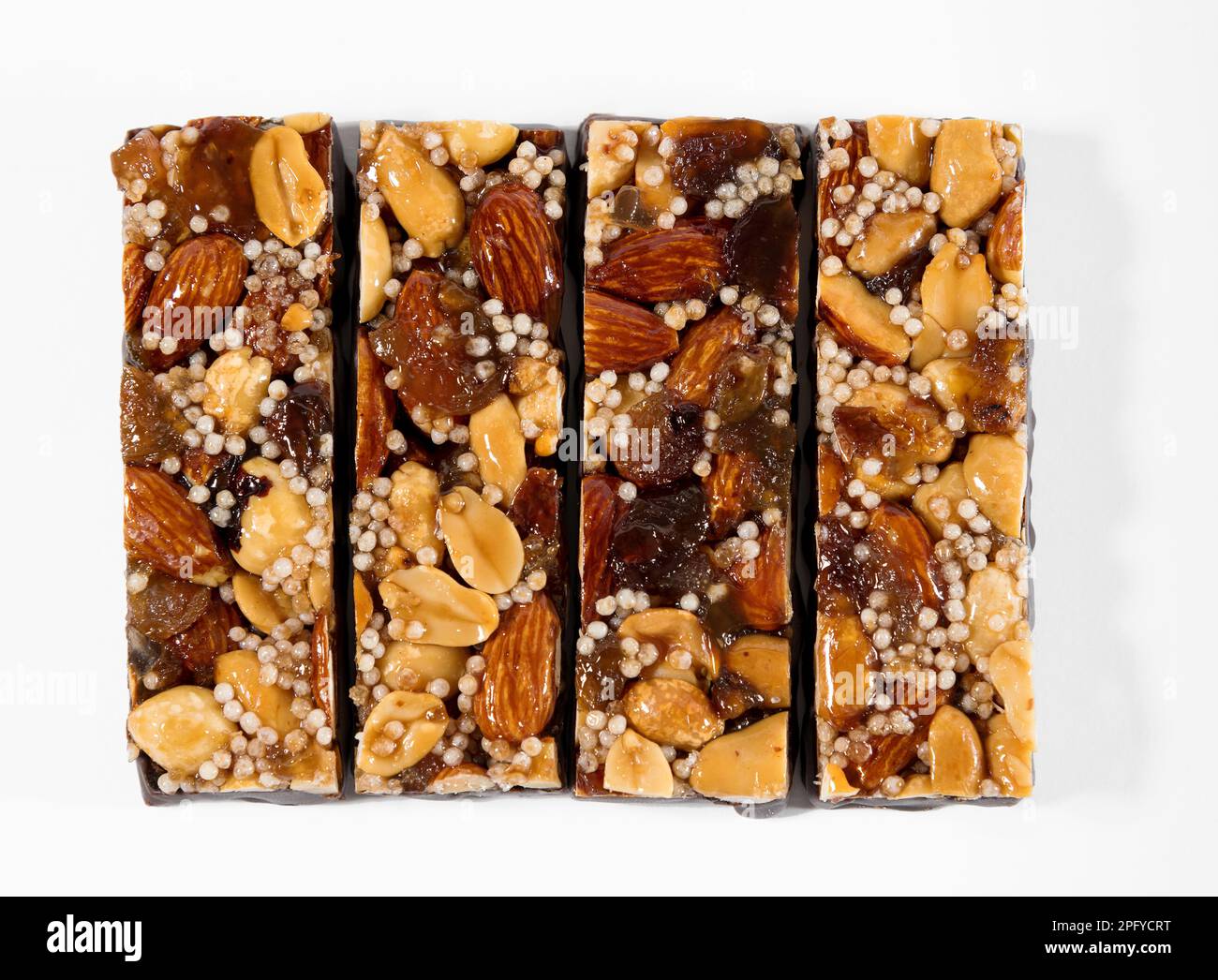 Vista superior de cuatro deliciosas barras de energía con nueces y semillas aisladas sobre fondo blanco Foto de stock