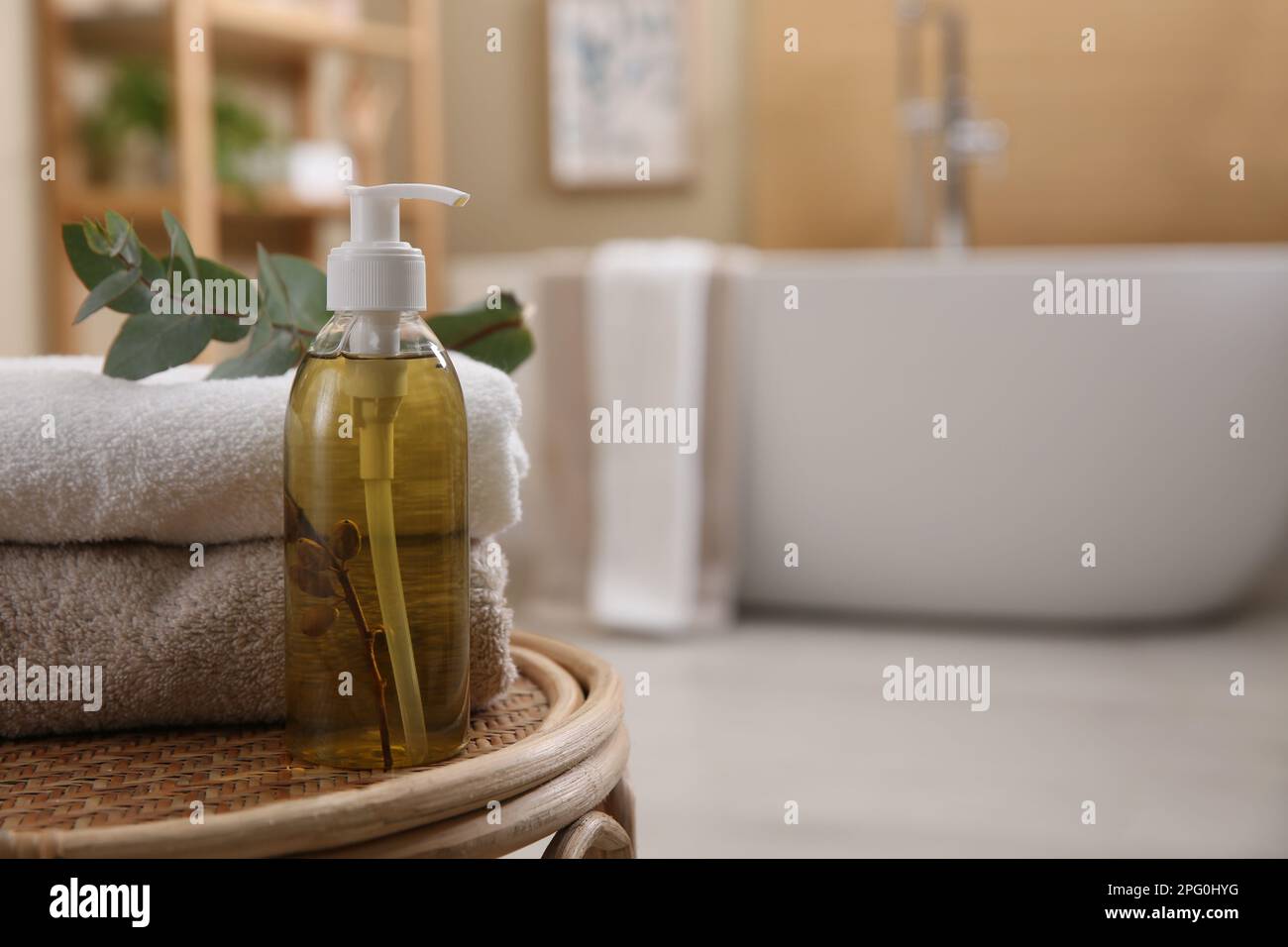 Dispensador de jabón líquido, toallas limpias y rama de eucalipto en el  taburete de mimbre en el baño. Espacio para texto Fotografía de stock -  Alamy