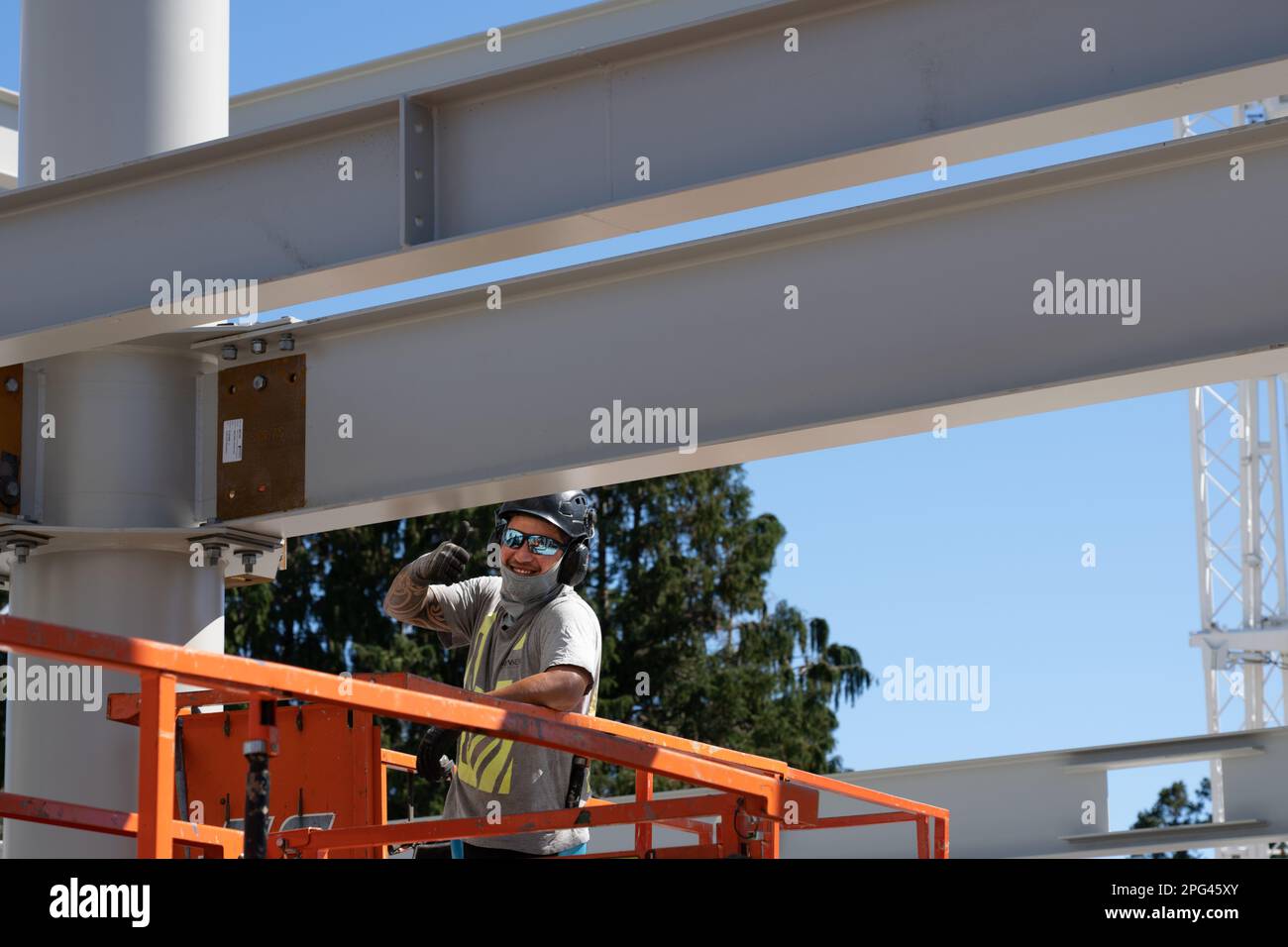 Tauranga Nueva Zelanda - Marzo 15 2023; Constructor con gafas reflectantes erigiendo vigas estructurales da pulgares hacia arriba. Foto de stock