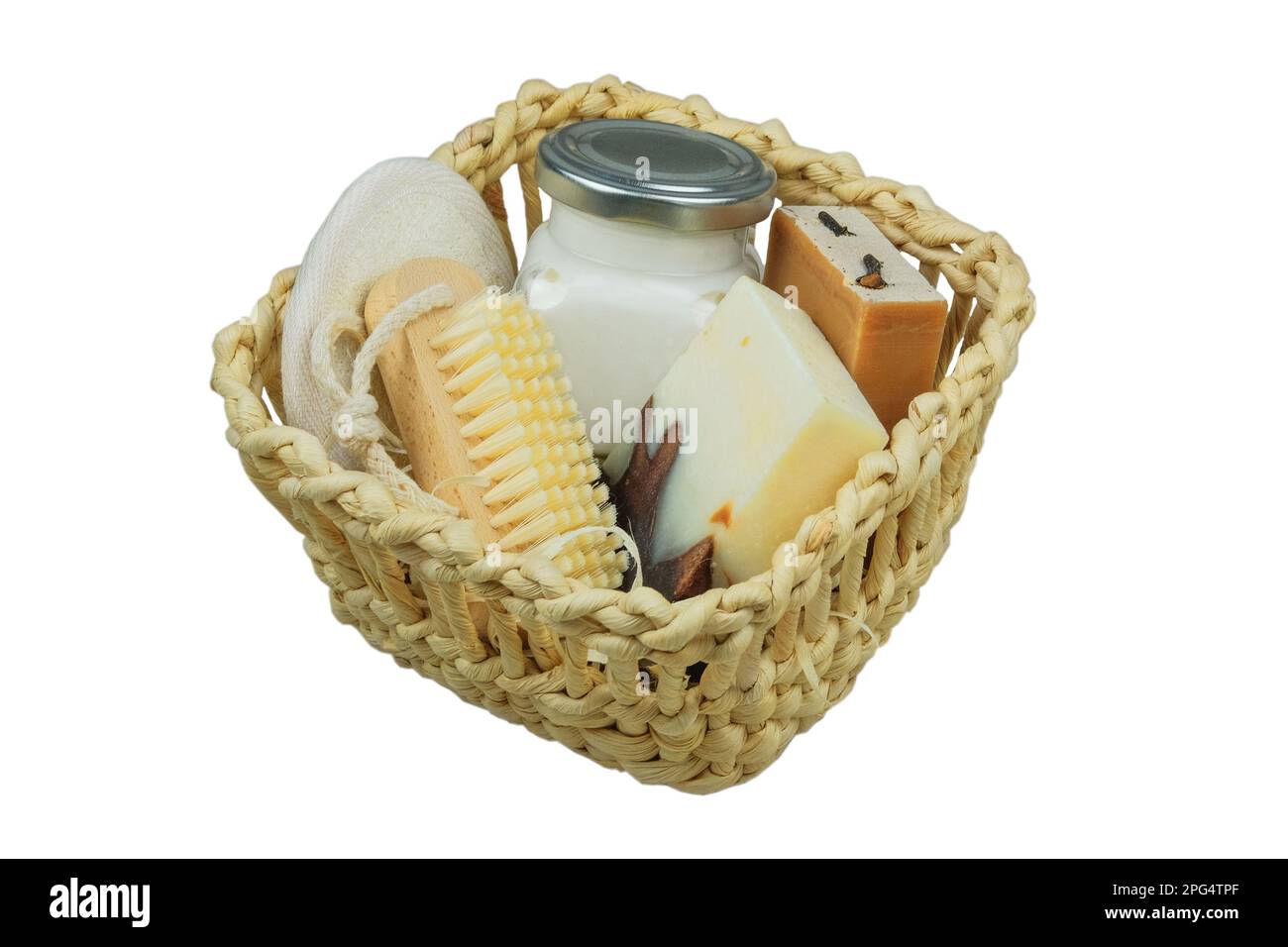 Productos cosméticos de la naturaleza. Productos cosméticos para el cuerpo y accesorios en una cesta de paja blanca. Aislar sobre fondo blanco. Foto de stock