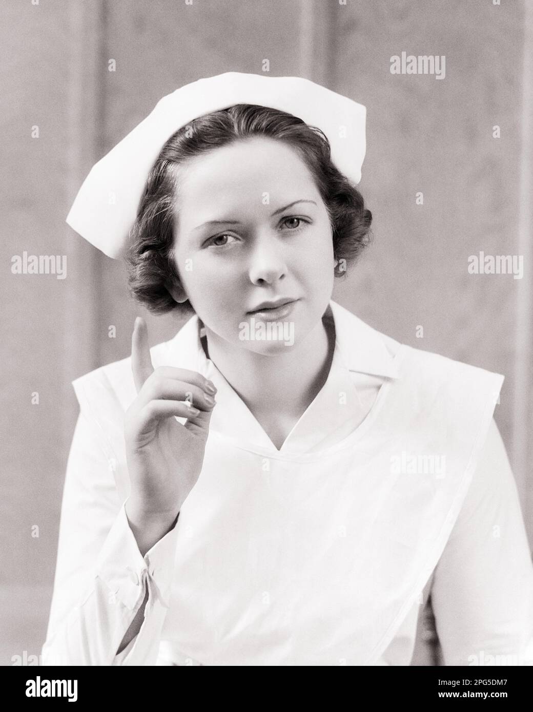 1940s Enfermera Femenina Seria Gesticulando Con Un Dedo Índice De Advertencia Dando Consejos