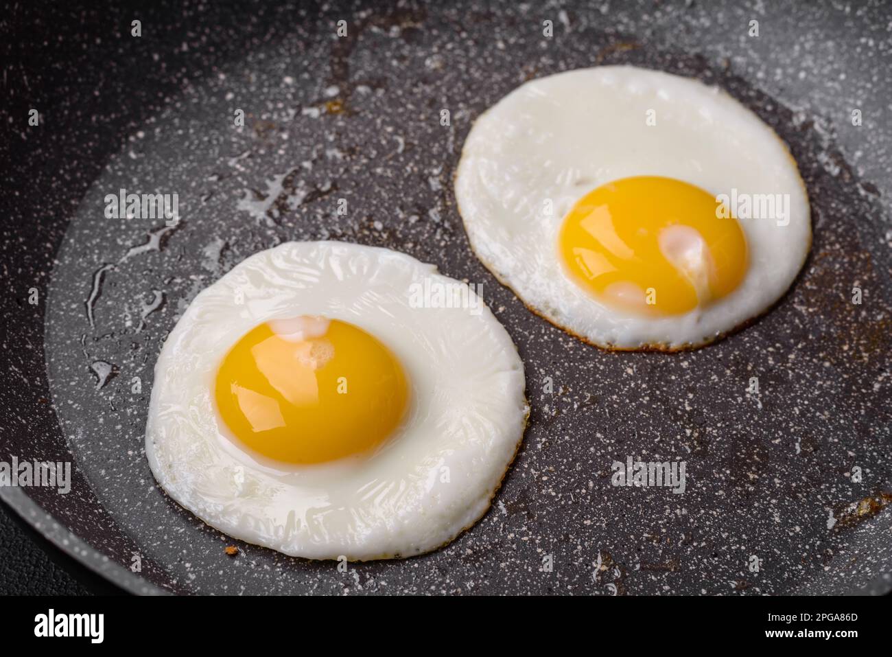 Delicioso desayuno inglés nutritivo con huevos fritos, tomates, tocino y  frijoles sobre un fondo de hormigón oscuro Fotografía de stock - Alamy