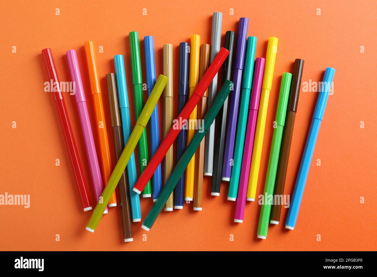 Muchos marcadores coloridos sobre fondo naranja, plano lay. Papelería  escolar Fotografía de stock - Alamy