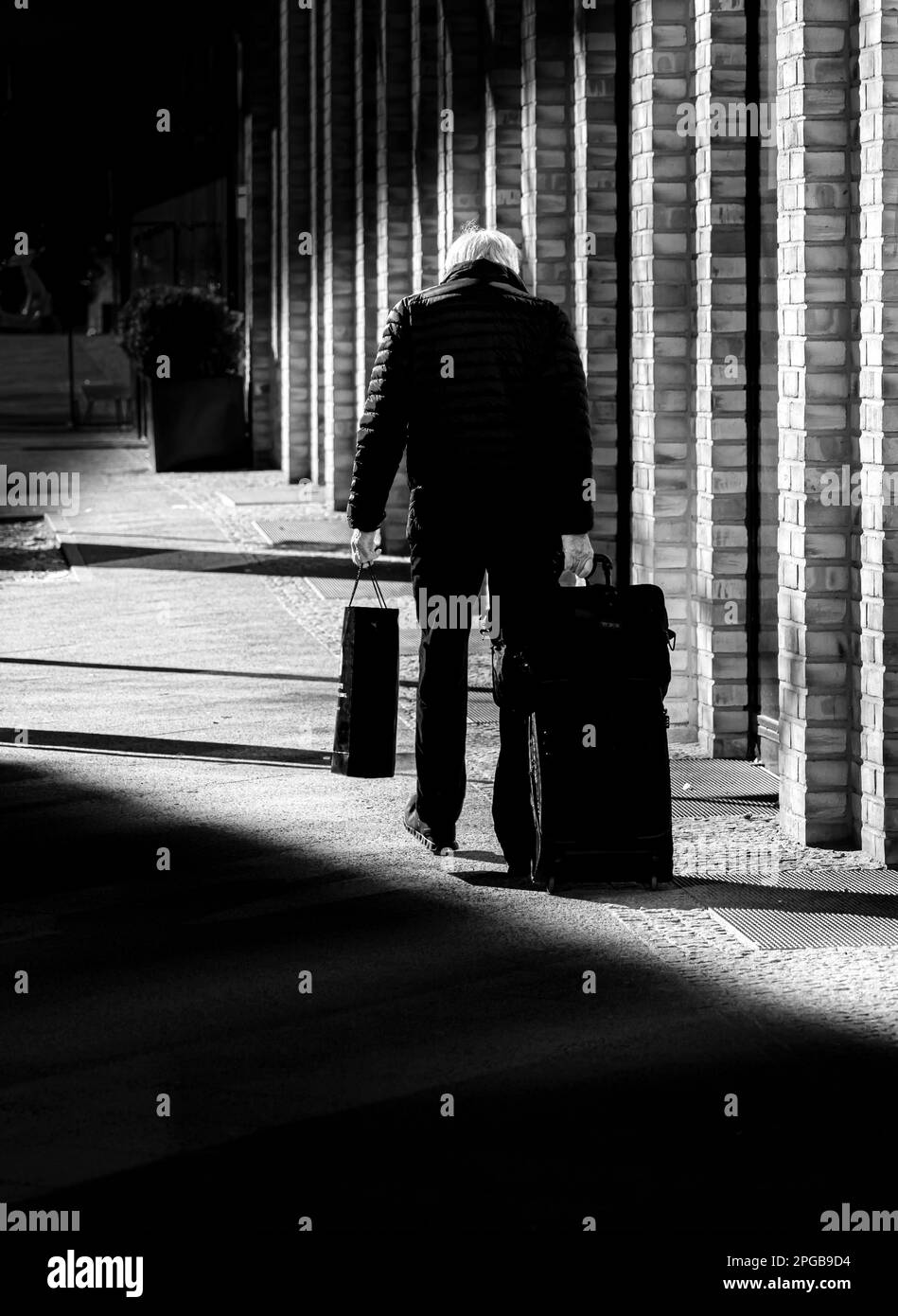 Fotografía en blanco y negro, persona mayor con maleta, Berlín, Alemania Foto de stock