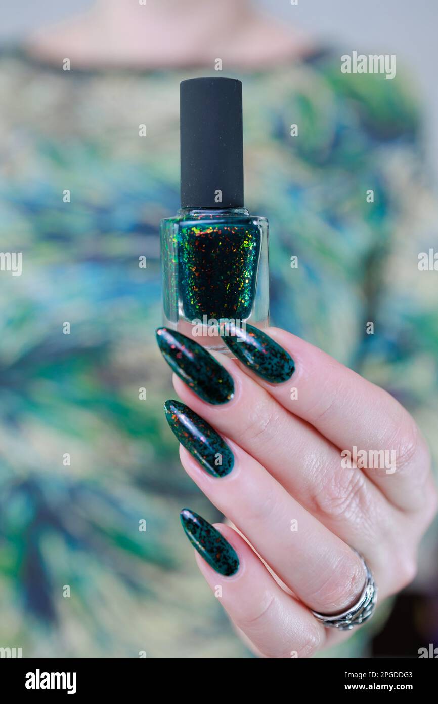 Mano de mujer con uñas largas y esmalte de uñas verde oscuro Fotografía de  stock - Alamy