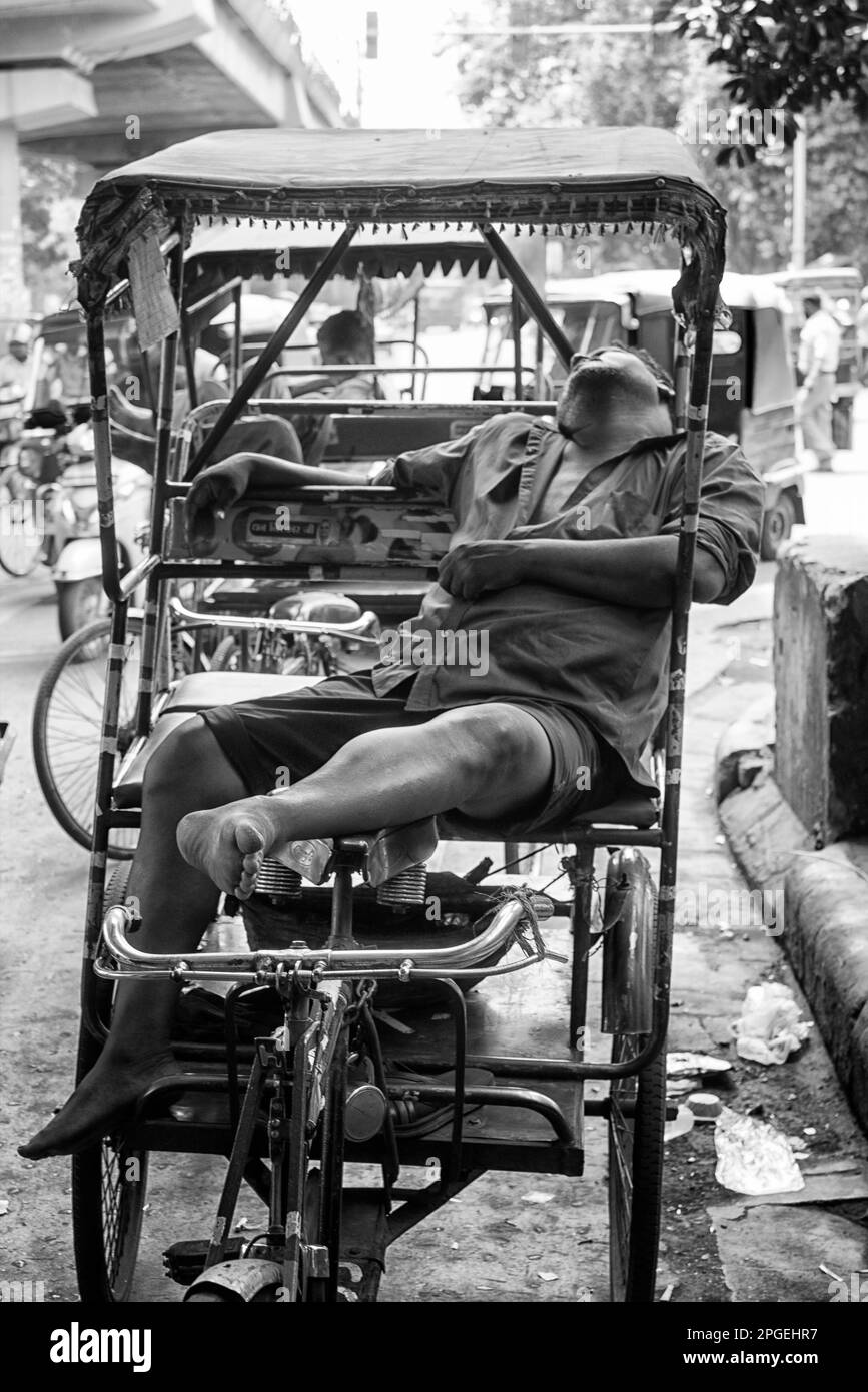 Un conductor de rickshaw tomando una siesta en su Rickshaw. Indio. Foto de stock