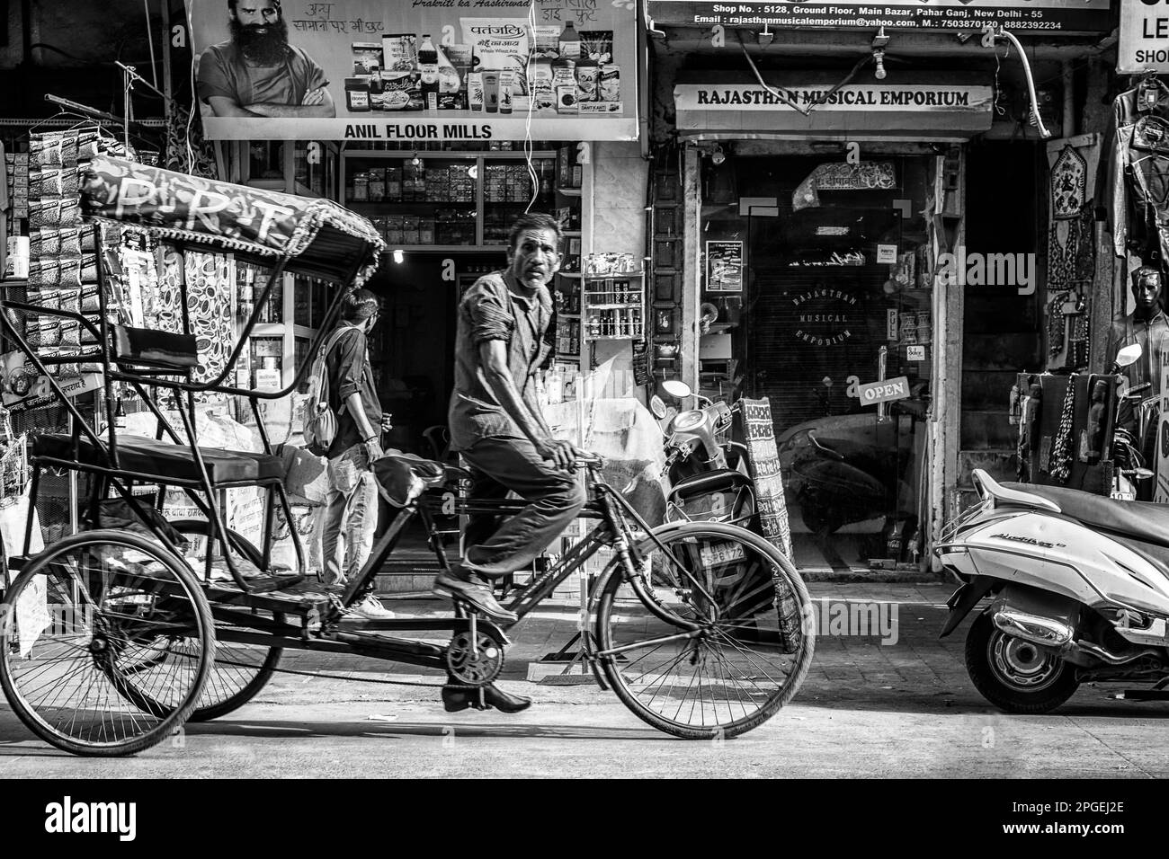 Un conductor de rickshaw montando su Rickshaw. Indio. Foto de stock