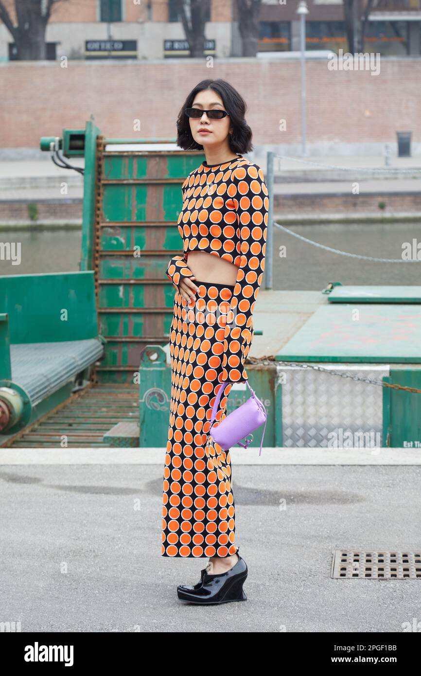 MILÁN, ITALIA - 24 DE FEBRERO de 2023: Mujer con top y falda con lunares naranja y negro antes del desfile Sportmax, Milan Fashion Week street sty Foto de stock
