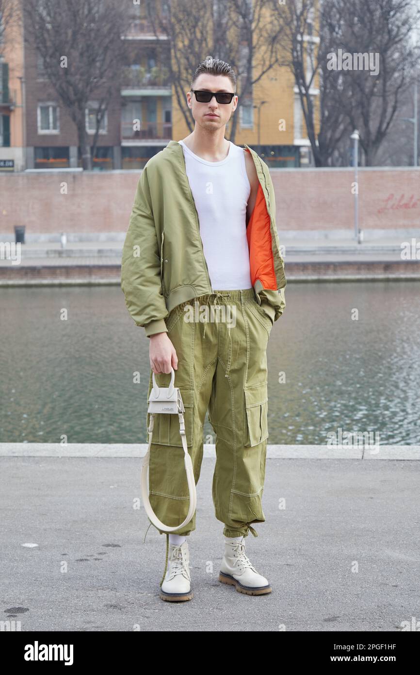 MILÁN, ITALIA - 24 DE FEBRERO de 2023: Hombre con chaqueta verde oliva y pantalón cargo antes del desfile Sportmax, Milan Fashion Week street style Foto de stock