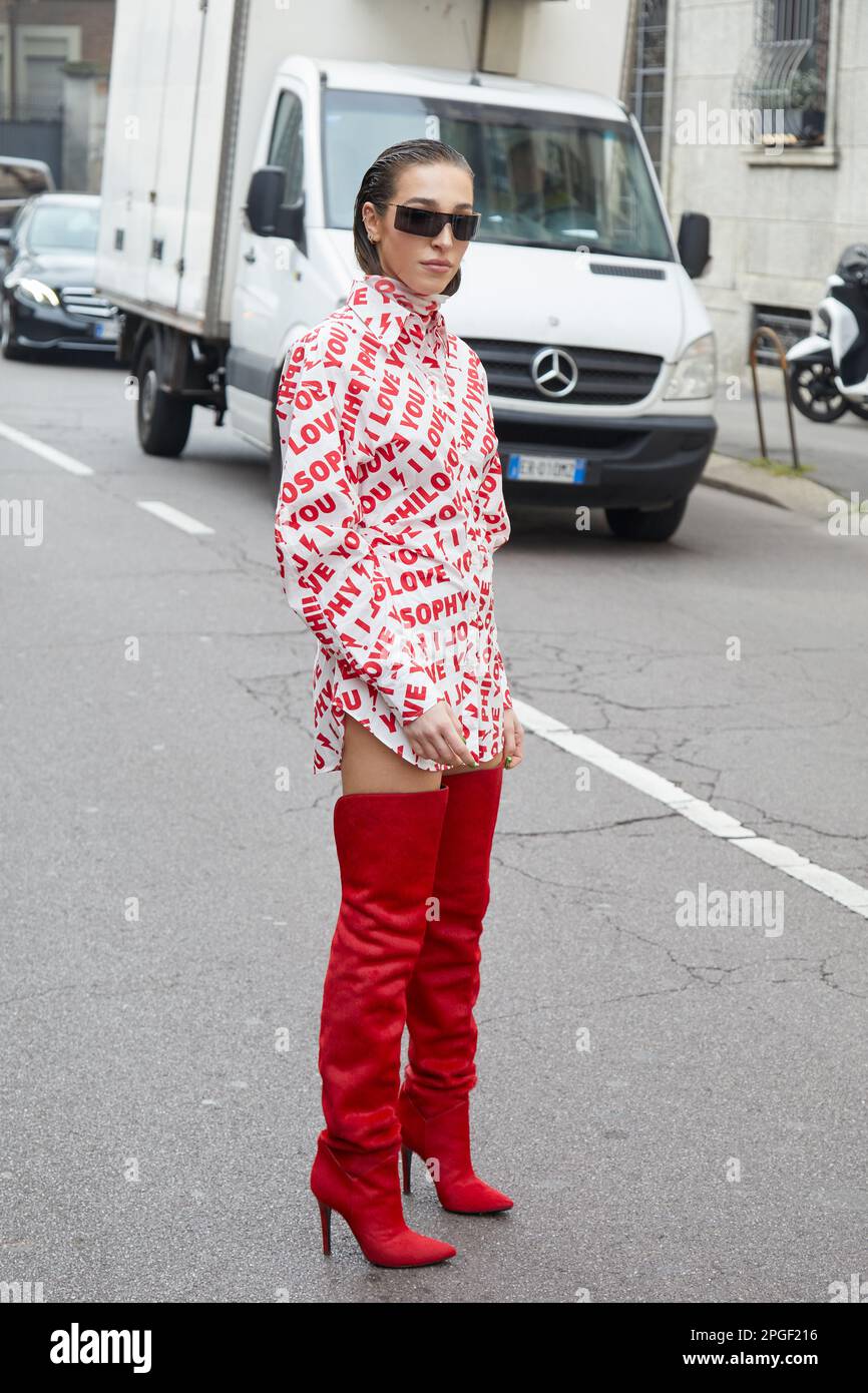 MILÁN, ITALIA - 24 DE FEBRERO de 2023: Ginevra Mavilla con vestido blanco con escritos rojos y botas rojas antes del desfile de moda Philosophy by Lorenzo Serafini, Foto de stock