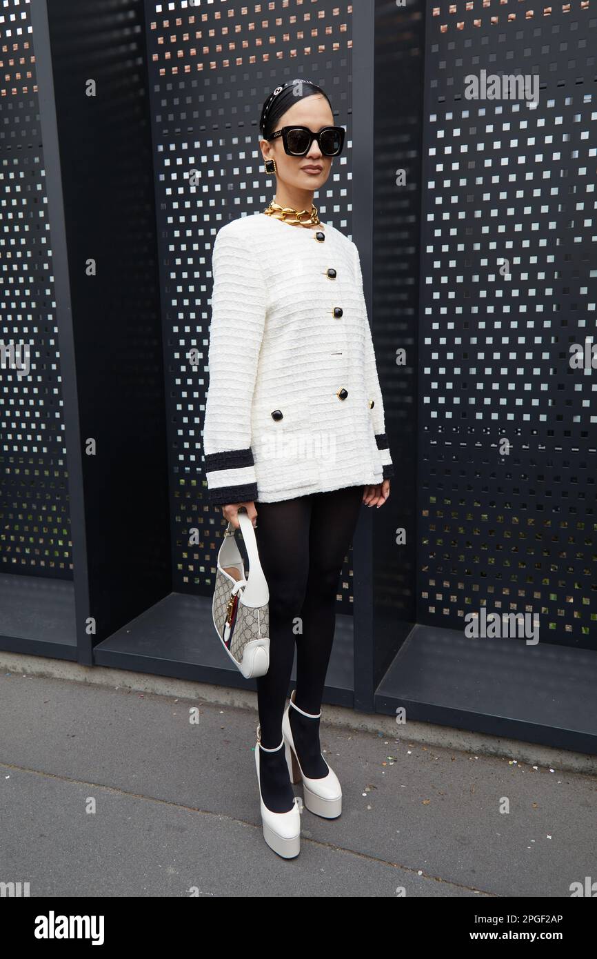 MILÁN, ITALIA - 24 DE FEBRERO de 2023: Mujer con chaqueta blanca y zapatos antes del desfile de Gucci, estilo callejero de la Semana de la Moda de Milán Foto de stock