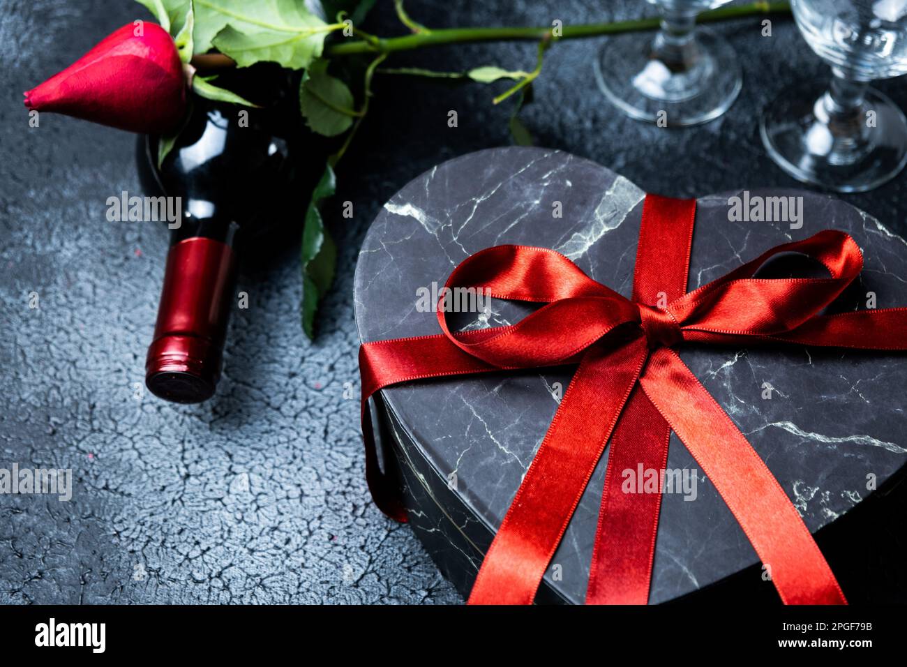 Concepto del día de San Valentín, noche romántica, vino tinto, caja de  regalo, rosa roja, copas, fondo negro, vista superior Fotografía de stock -  Alamy