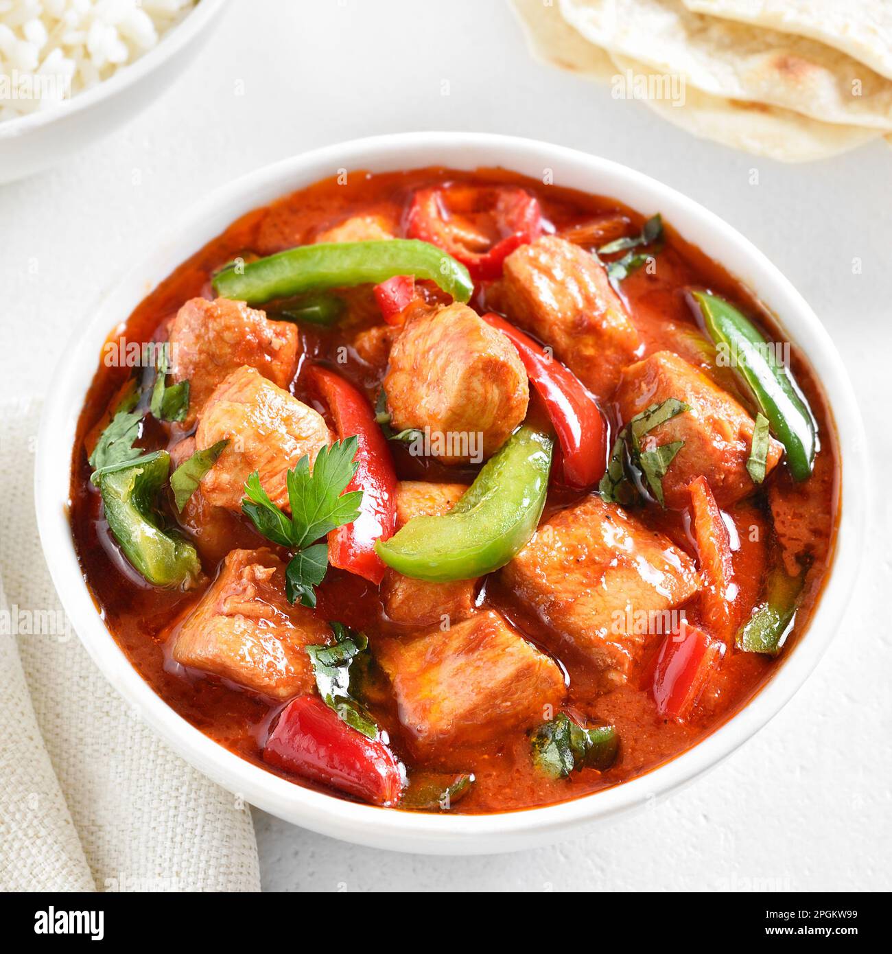 Curry de pollo rojo estilo tailandés con verduras en tazón sobre fondo claro. Vista de primer plano Foto de stock