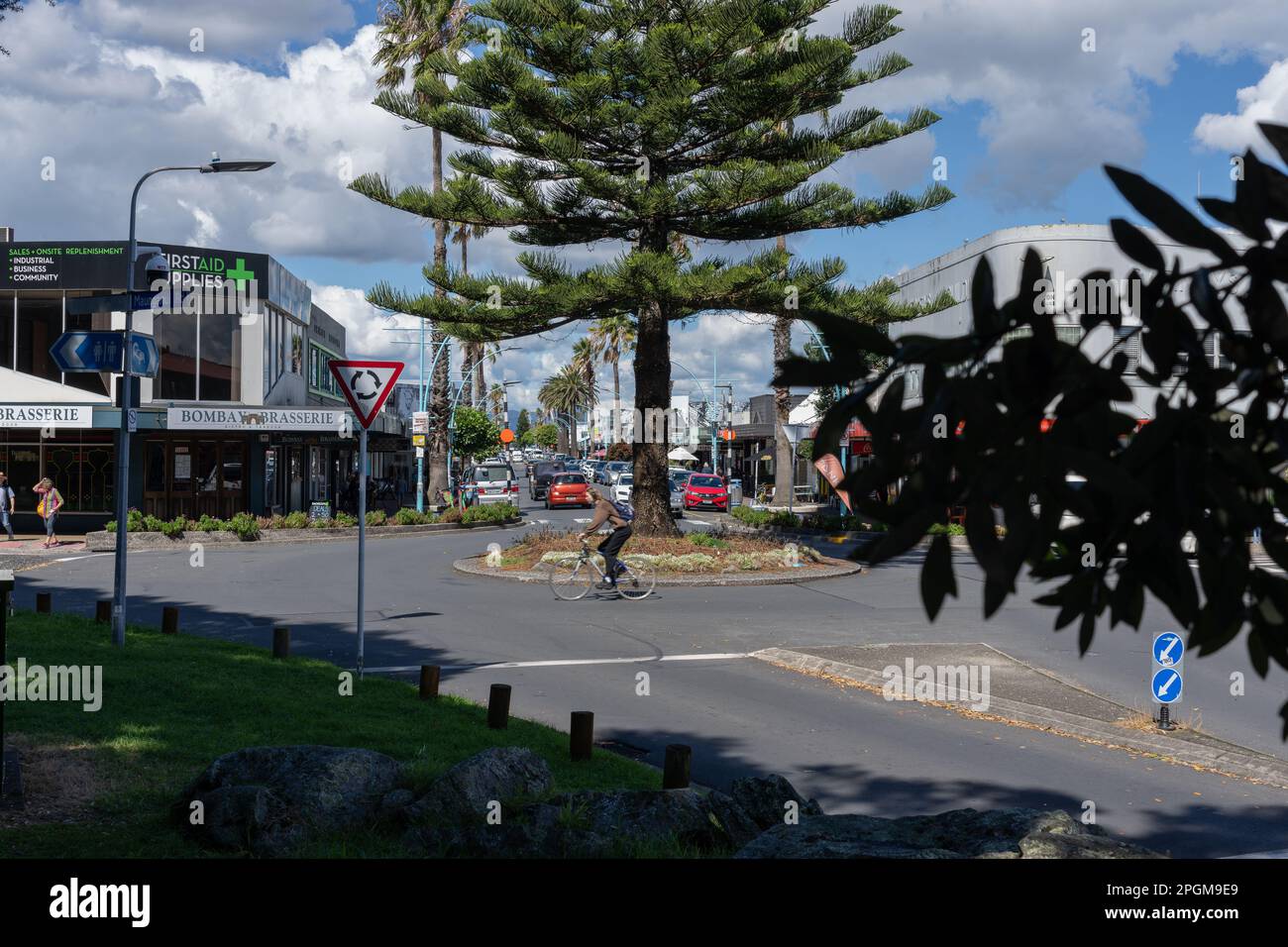 Tauranga Nueva Zelanda - 22 2023 de marzo; Tauranga Nueva Zelanda - 22 2023 de marzo; ciclista borroso en movimiento montando alrededor del jardín de la rotonda y la calle inter Foto de stock