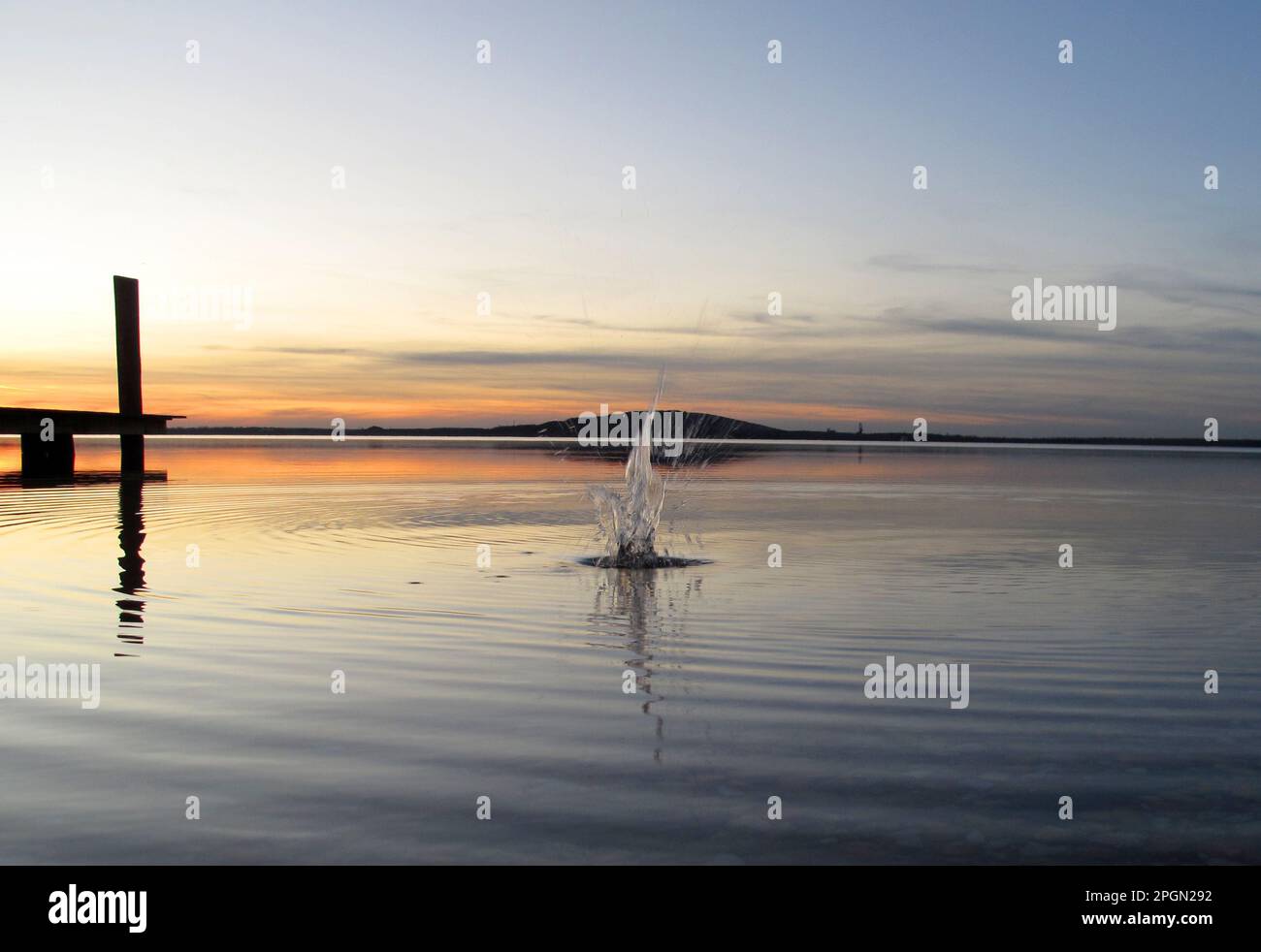 El agua salpica en un lago por la noche con el espejo como el agua  Fotografía de stock - Alamy