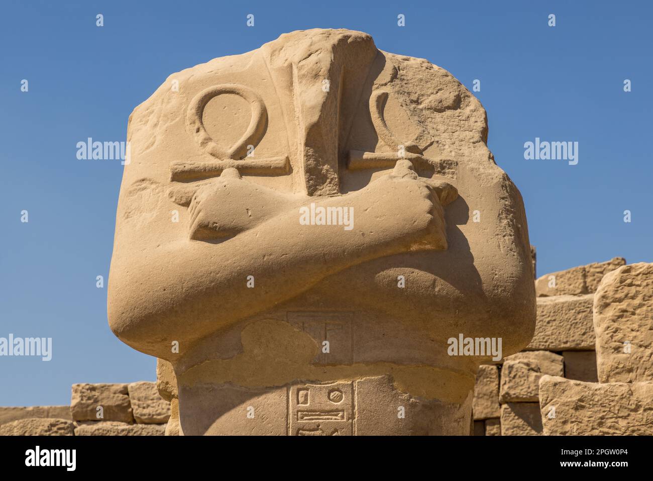 Estatua sin cabeza de un faraón sosteniendo cruces de tobillos en ambas manos Foto de stock
