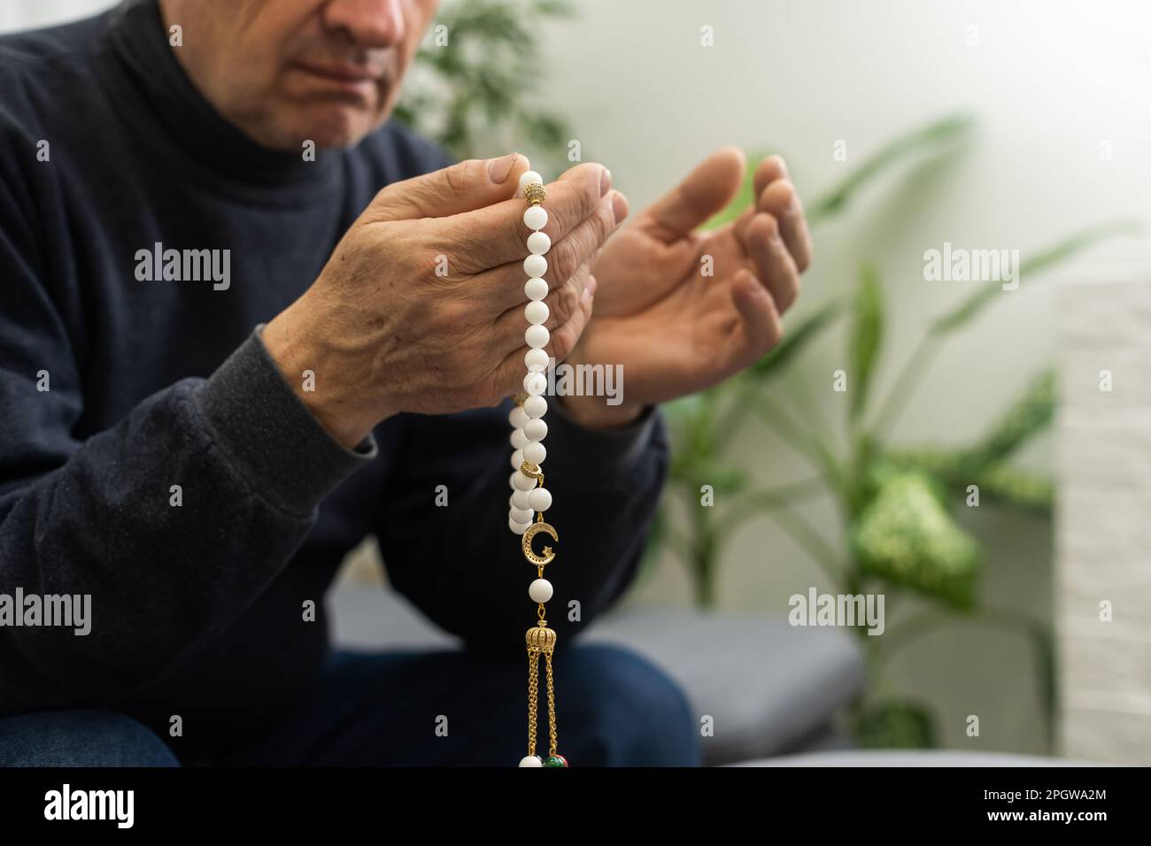 Un anciano reza con un rosario y la bandera de los Emiratos Árabes Unidos  Fotografía de stock - Alamy
