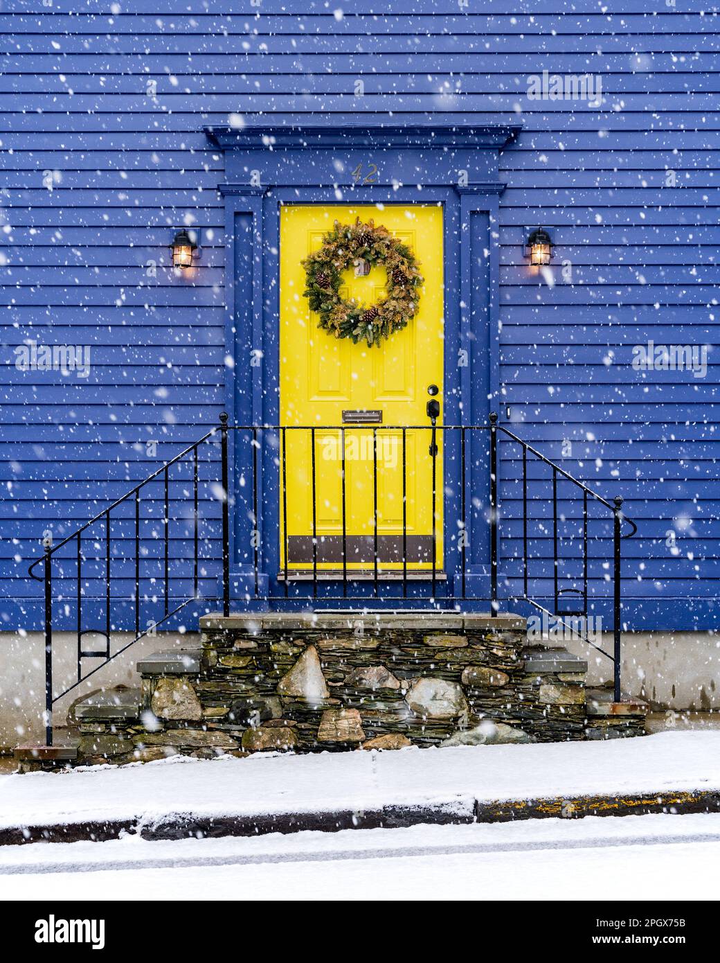 Fotografía llamativa de una casa de dos pisos con una puerta amarilla  distintiva y paredes azul celeste contra un paisaje prístino cubierto de  nieve Fotografía de stock - Alamy