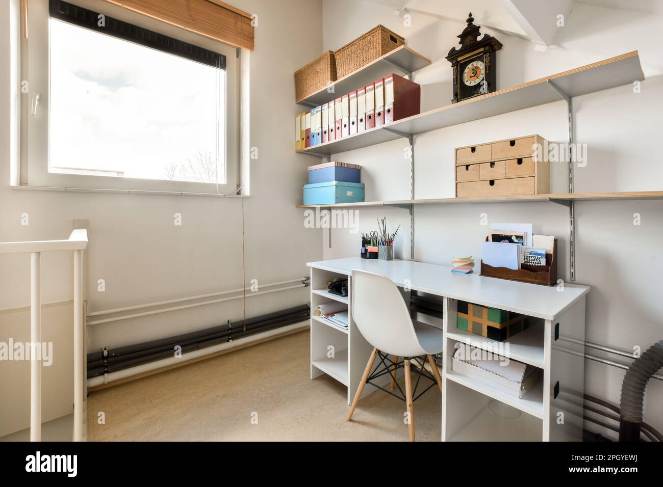 área de oficina en casa con paredes blancas y estantes de madera en pared está llena varios tipos de cajas de almacenamiento de stock - Alamy
