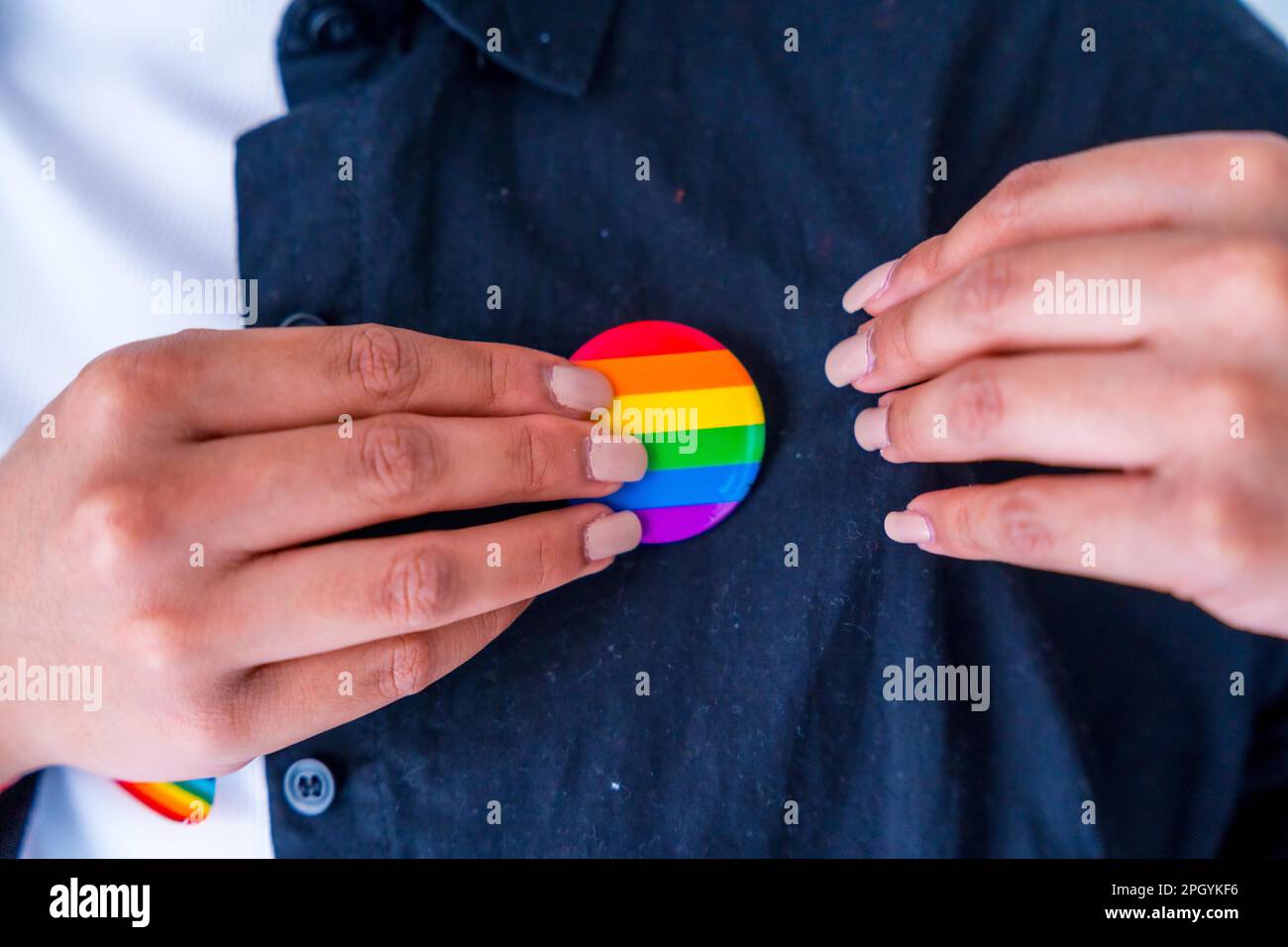 Hombre con el bolso reutilizable del arco iris y la insignia lgbt, mes del orgullo Foto de stock