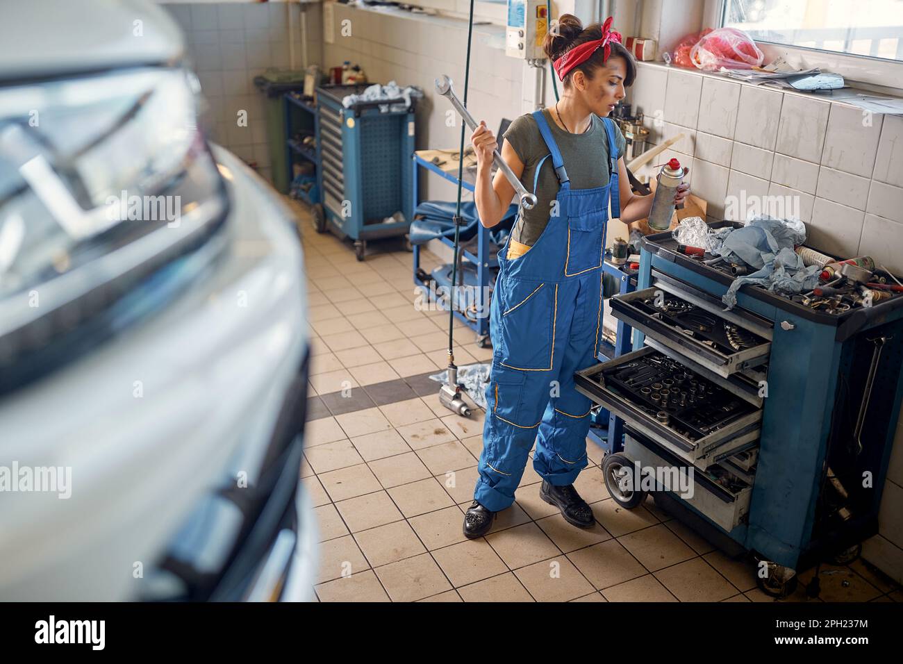 Mujer mecánica working.young mecánico femenino divirtiéndose en el trabajo Foto de stock