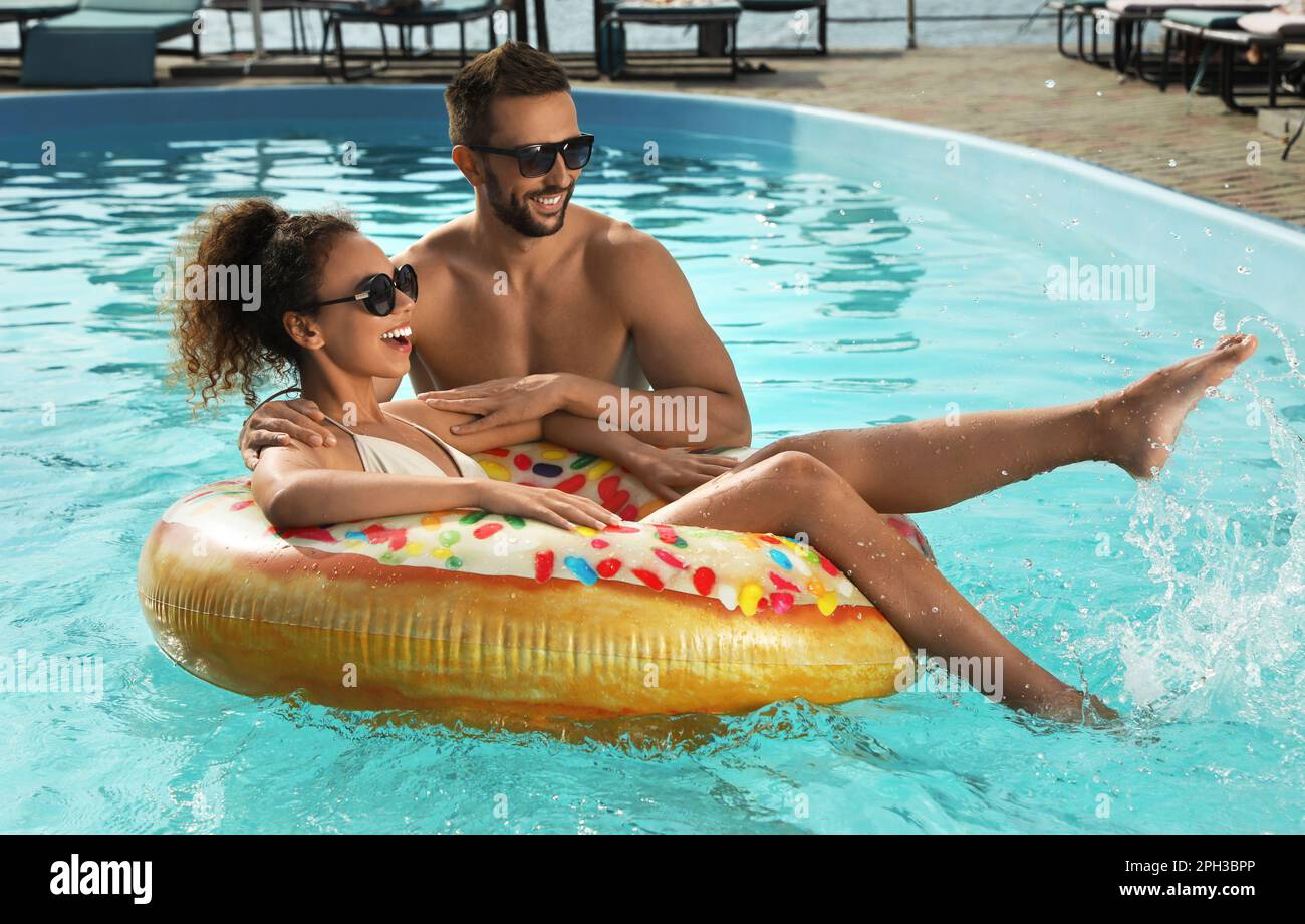 mujer feliz en traje de baño blanco con anillo de natación amarillo en  hotel de lujo
