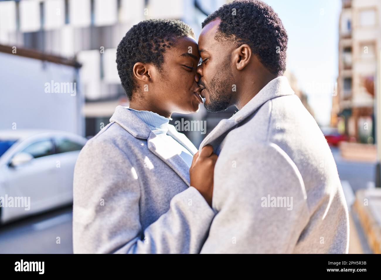 Pareja de hombres y mujeres abrazándose unos a otros y besándose en la  calle Fotografía de stock - Alamy