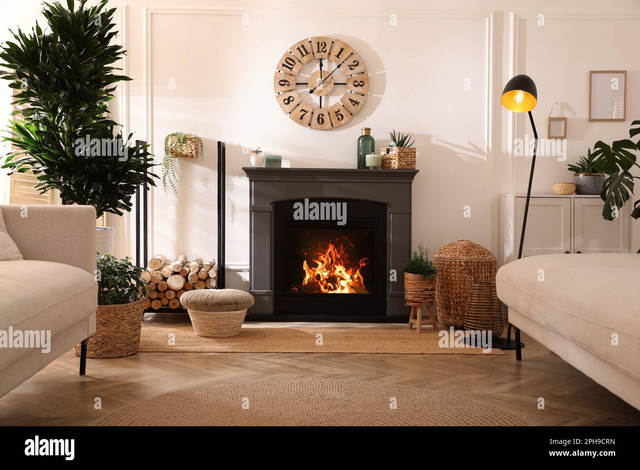 Elegante interior de la sala de estar con chimenea eléctrica, cómodos sofás  y hermosos elementos de decoración Fotografía de stock - Alamy