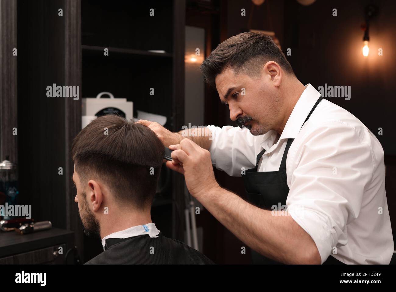 Peluquería profesional que hace corte de pelo elegante en barbería  Fotografía de stock - Alamy