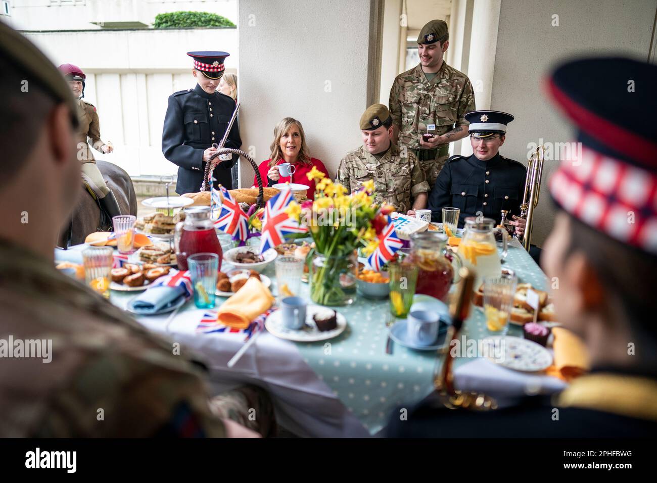 El presentador Mel Geidroyc con miembros de los guardias escoceses y los guardias de Coldstream durante el Gran almuerzo de coronación con militares en Wellington Barracks, Londres. Fecha de la fotografía: Martes 28 de marzo de 2023. Foto de stock