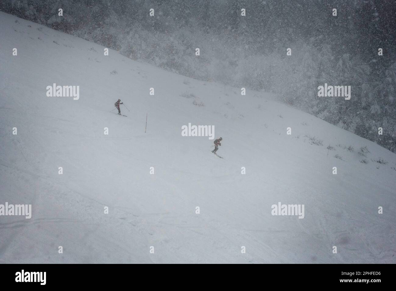 Dos esquiando en una pista muy nevada Foto de stock