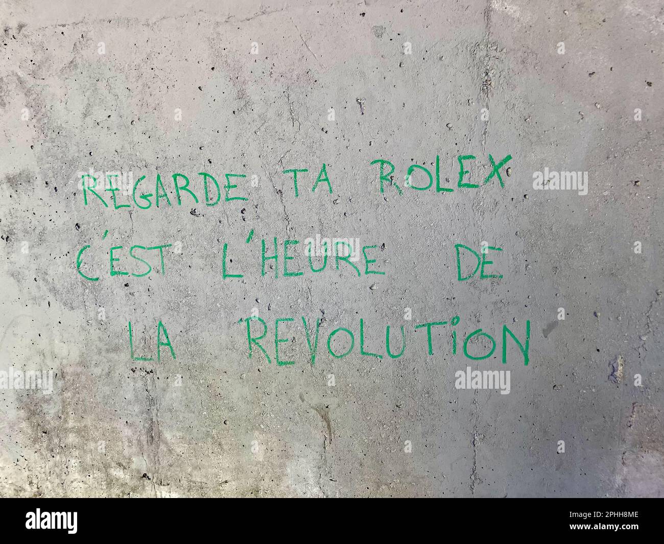 París, Francia - 7 de octubre de 2022: Arte revolucionario de graffiti en el distrito 12th 'Regarde ta Rolex C'est L'heure de la Revolution' Foto de stock