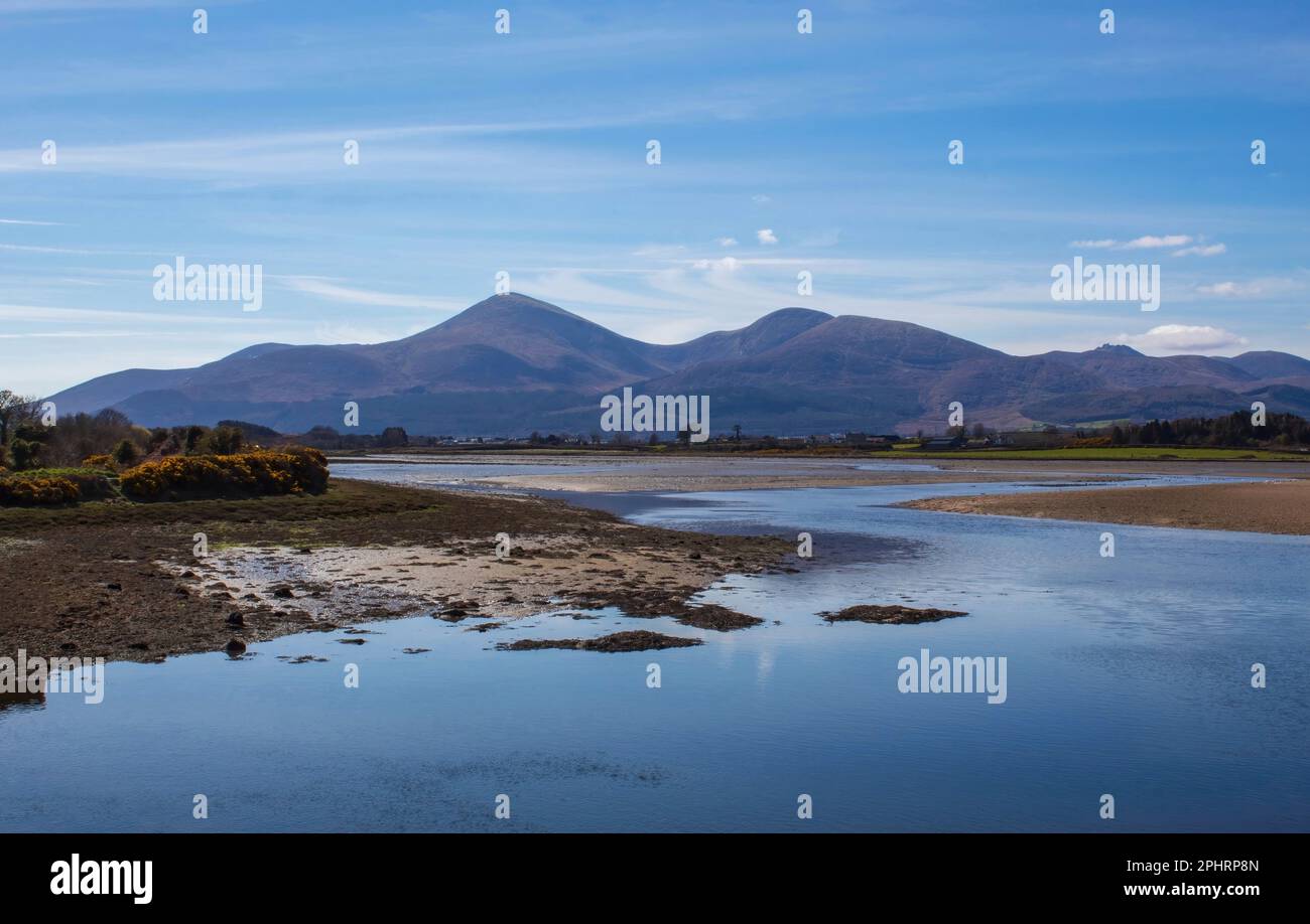 Las montañas Mourne en Irlanda del Norte tomadas de la bahía de Dundrum con la marea baja Foto de stock