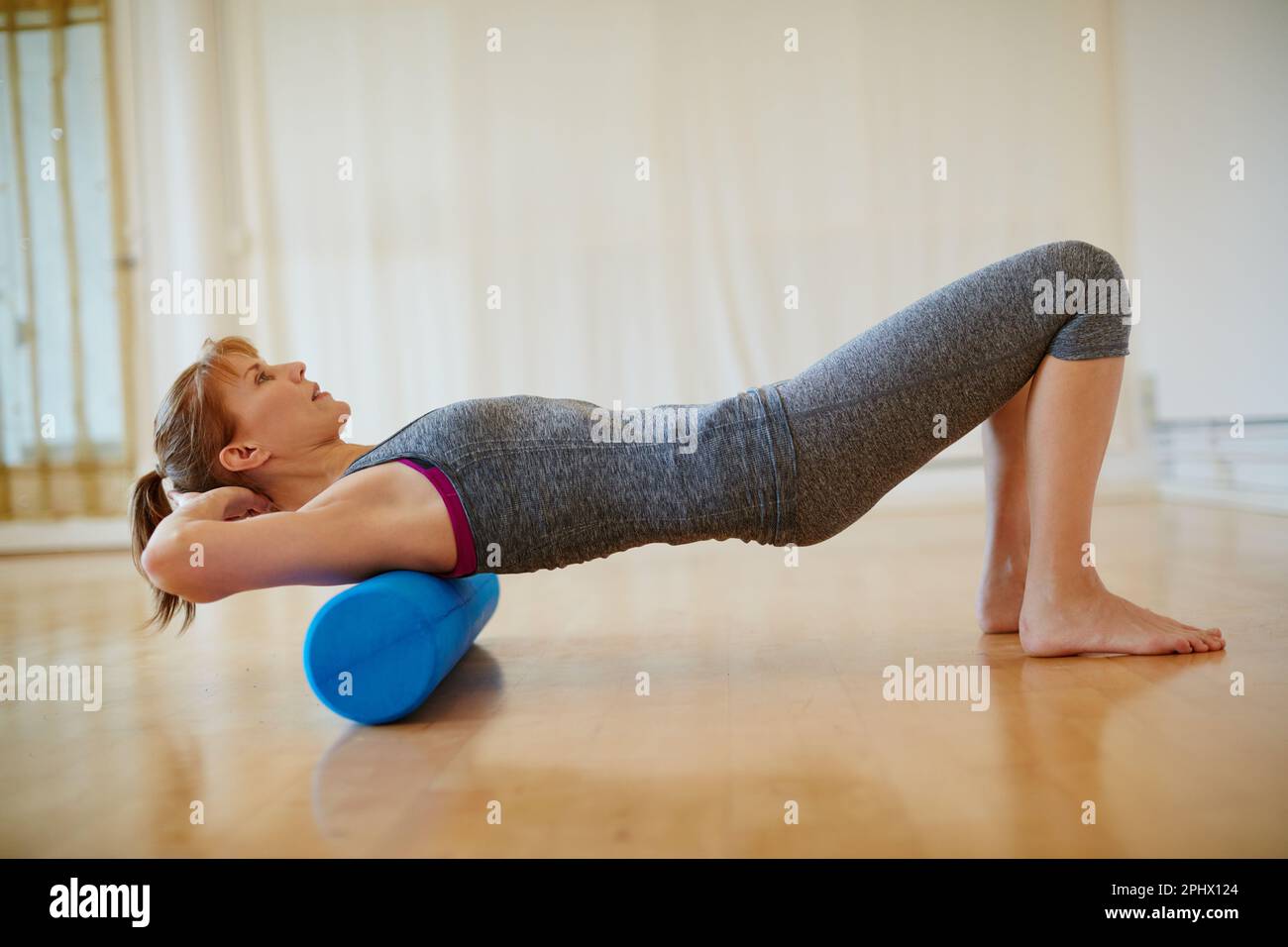 Mantener esos músculos flexibles y fuertes. una mujer haciendo ejercicios  de espuma de rodillo durante un entrenamiento de yoga Fotografía de stock -  Alamy