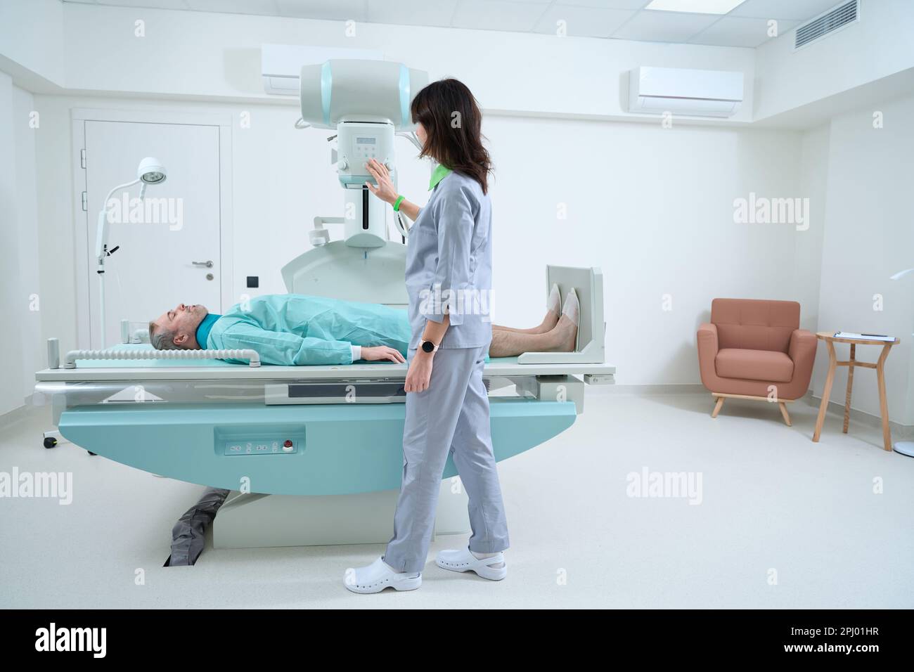 Radiólogo femenino que controla el proceso de rayos X en la clínica Fotografía de stock Alamy