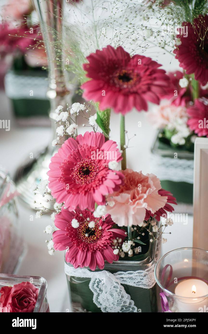 Una colección de pequeños y delicados arreglos florales con flores de color  rosa claro y blanco, engarzados en un jarrón de vidrio transparente  Fotografía de stock - Alamy