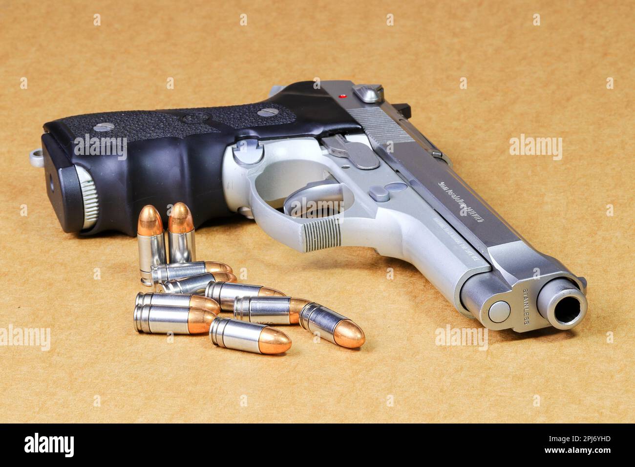 Bala 9mm parabellum y Beretta 92FS, pistola M9 sobre fondo de papel marrón. Foto de stock