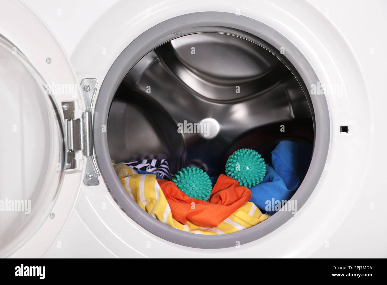 Bolas de secadora verde y ropa en tambor de lavadora Fotografía de stock -  Alamy