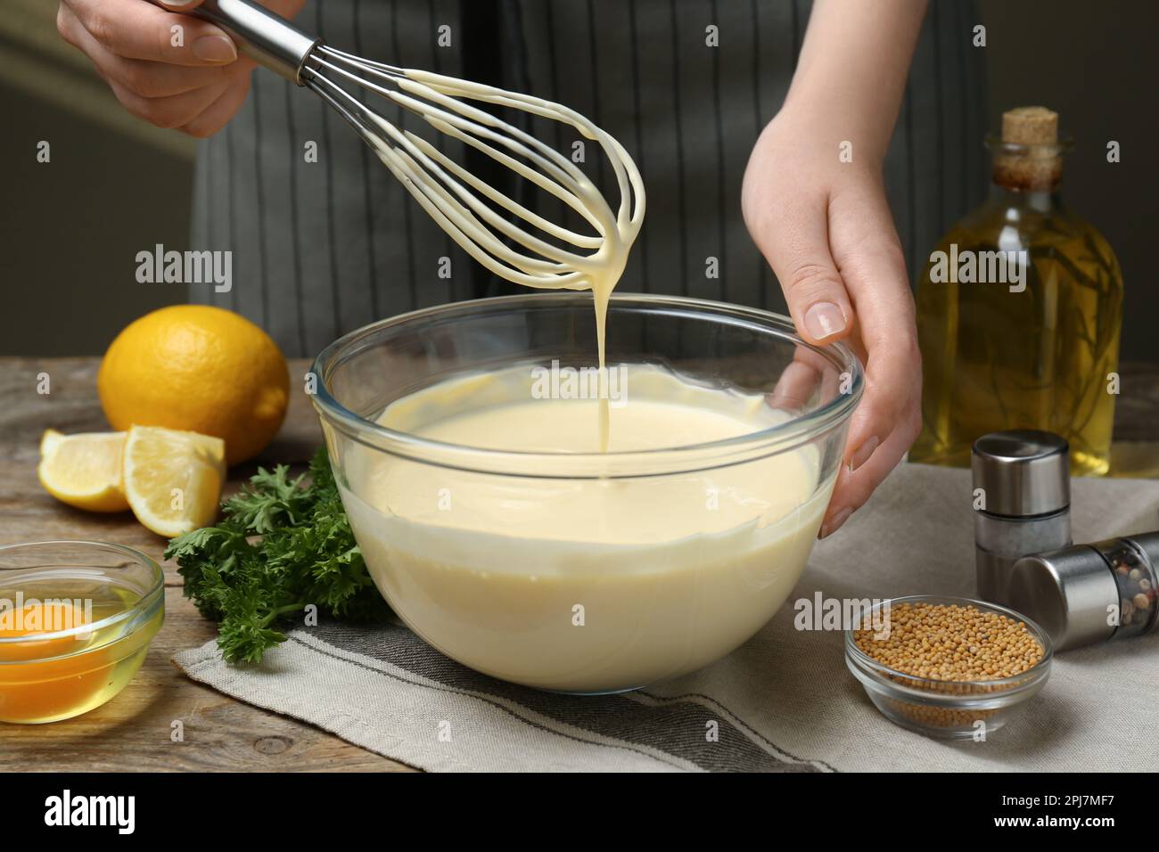 Mujer haciendo mayonesa casera en tazón de vidrio en la mesa de