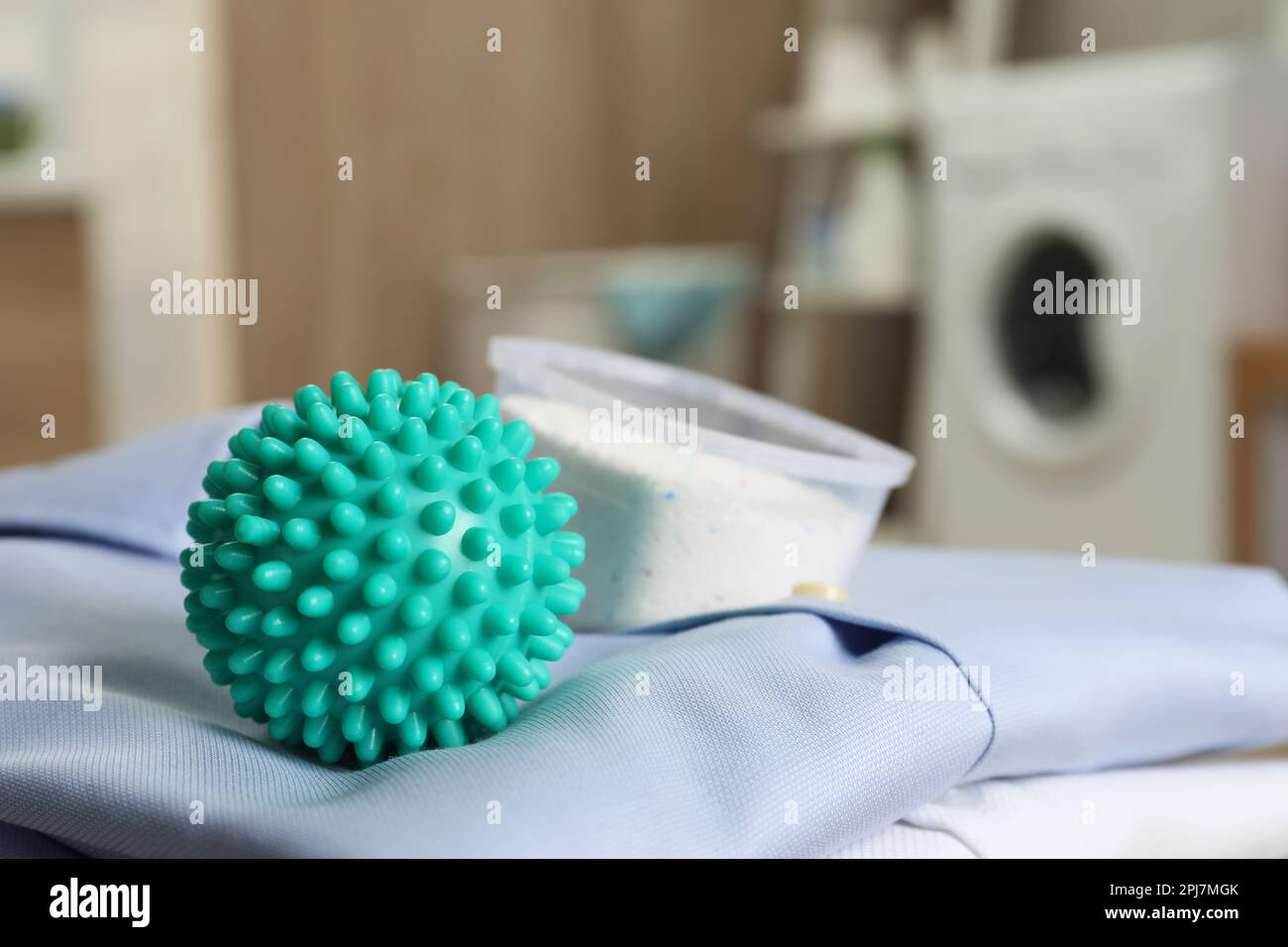 Bola de secadora turquesa y detergente en la ropa limpia en la lavandería,  primer plano Fotografía de stock - Alamy